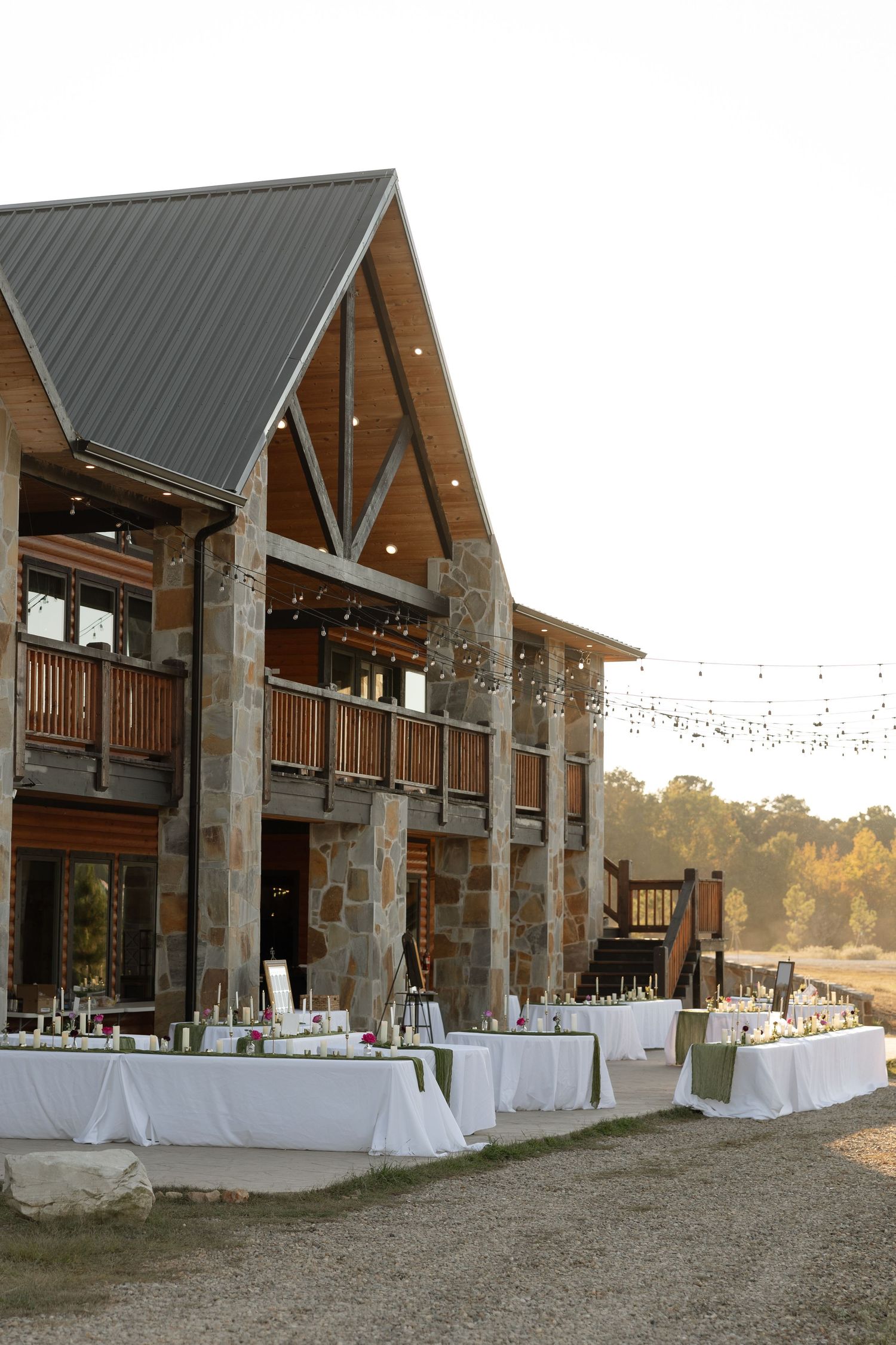 Stone and wood lodge venue with outdoor reception tables set up on the patio.