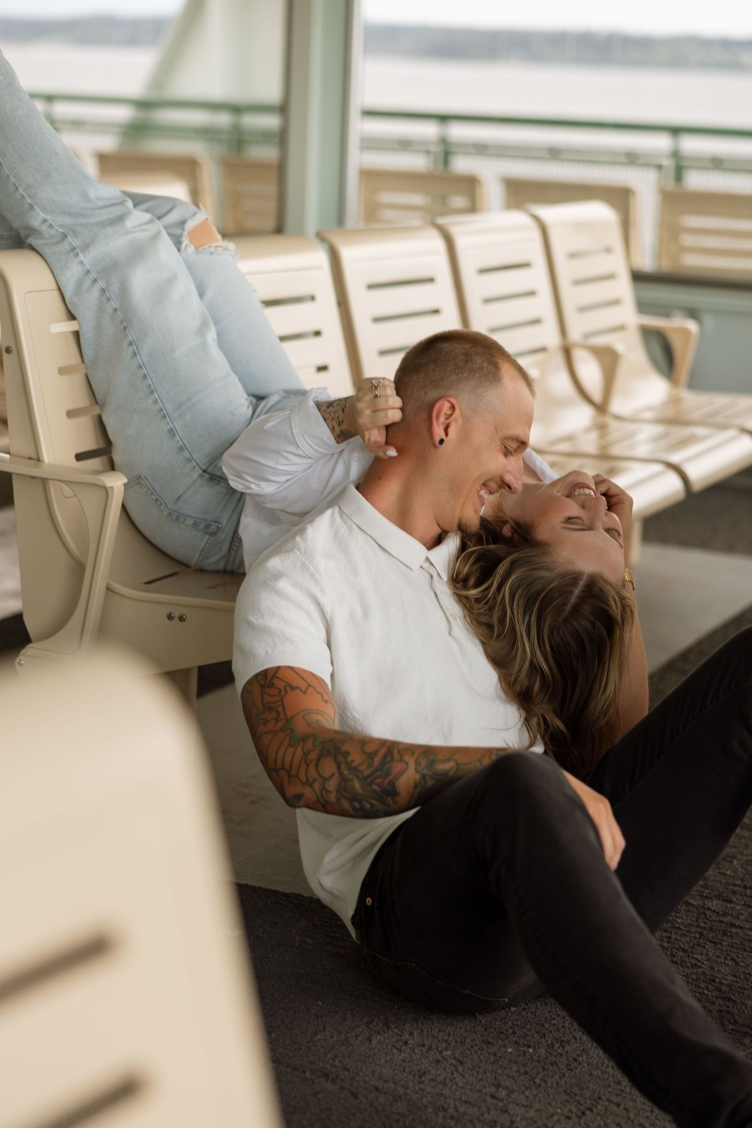 Couple sharing intimate moment on ferry bench seats.