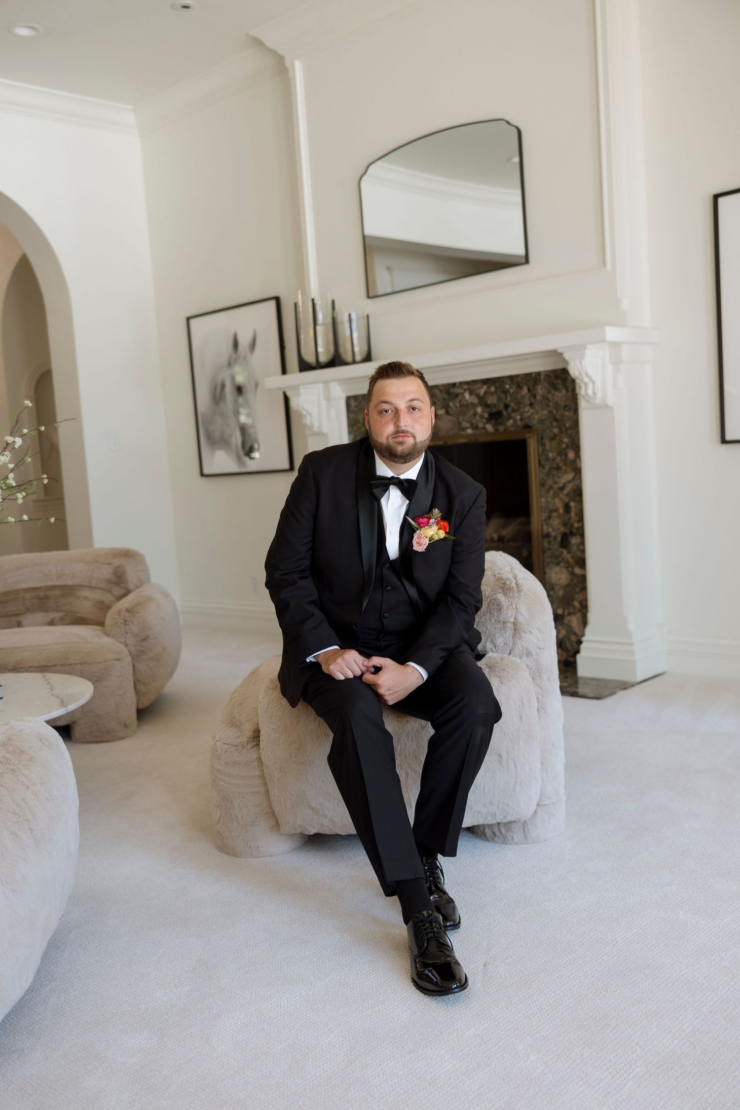 Elegant interior scene showing black formal attire against light carpeting and curved architectural details.
