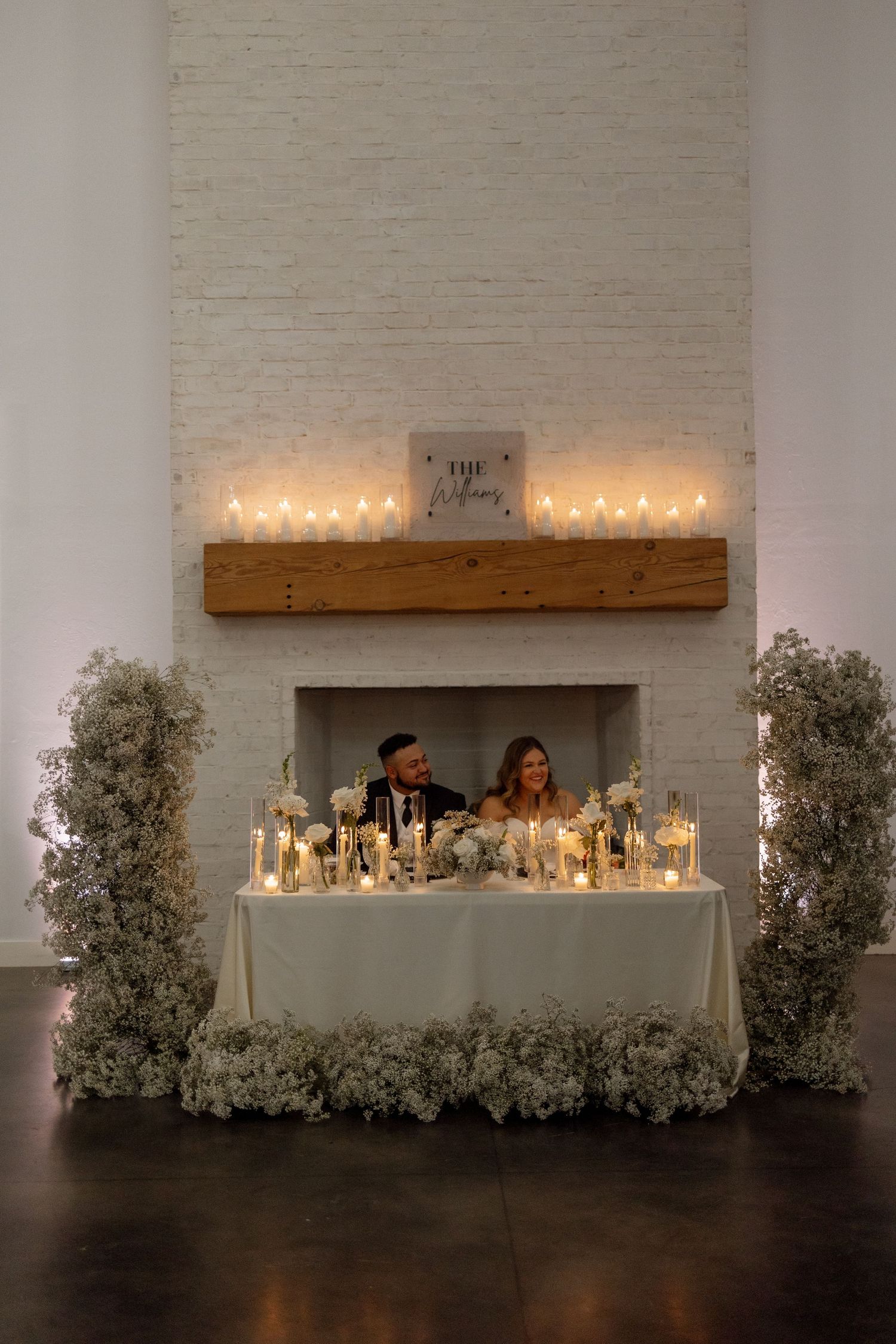 A beautifully decorated sweetheart table with candles and floral arrangements at a wedding reception.