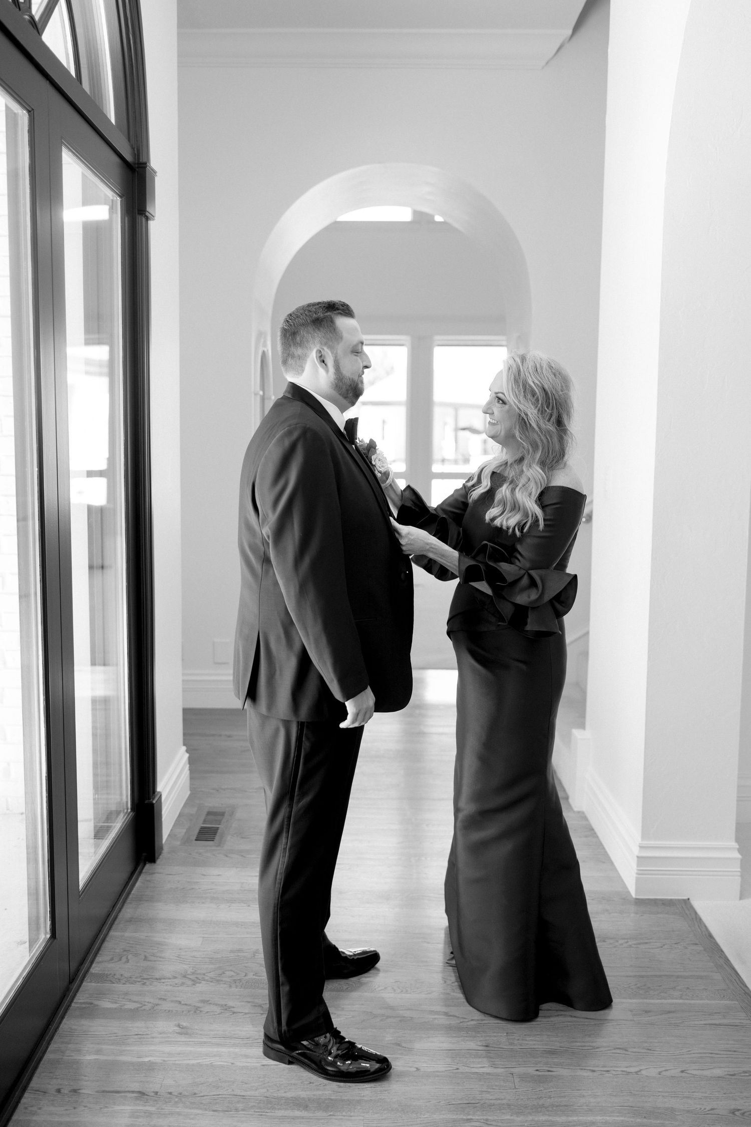 Black and white photos showing couple dancing in an elegant hallway.