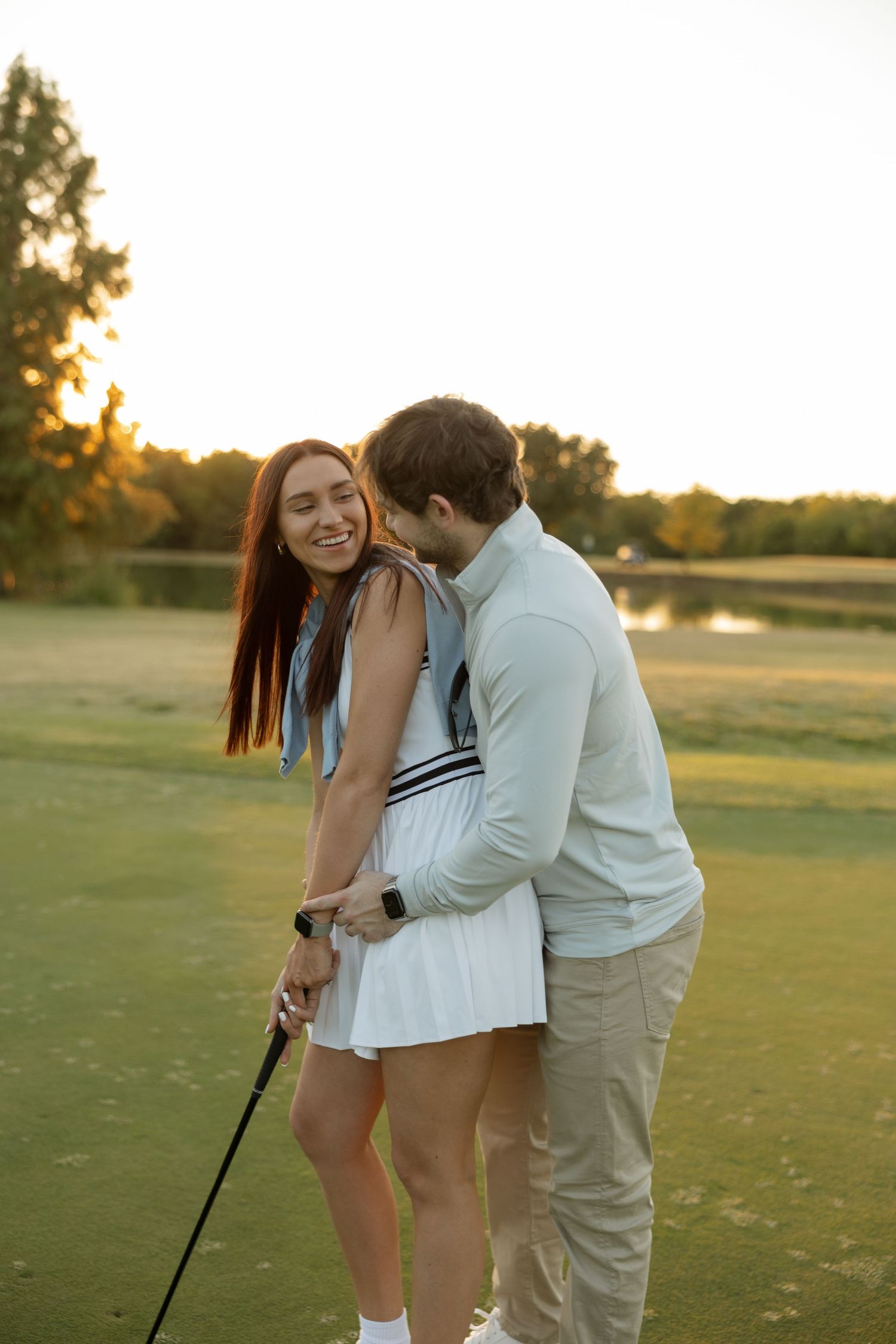 A romantic sunset moment on a golf course with a couple enjoying time together.