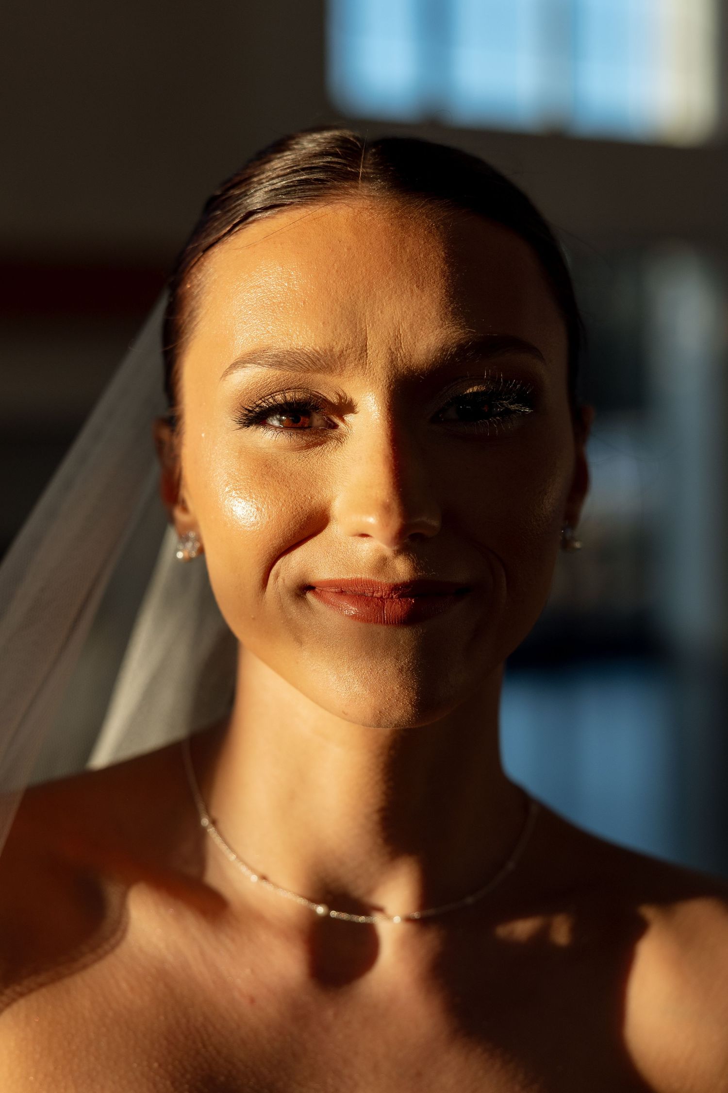 Sunlit bridal portrait showcasing elegant makeup and jewelry.