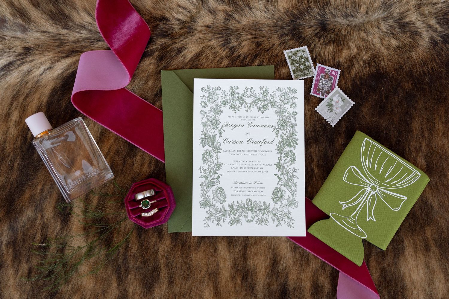 Elegant wedding stationery with green floral design and burgundy ring box on furry background.