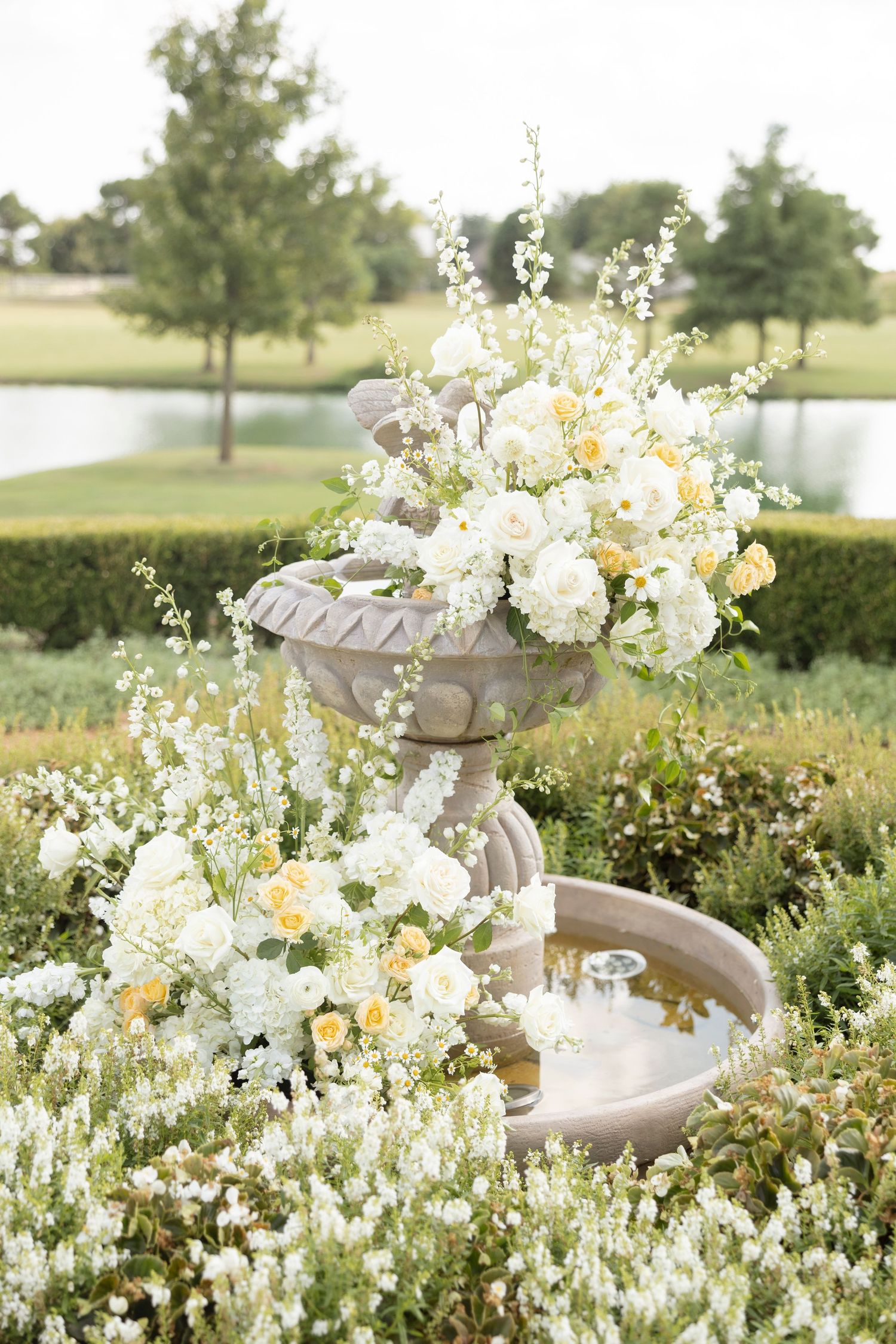 Romantic white and yellow floral arrangements adorning an outdoor garden setting.
