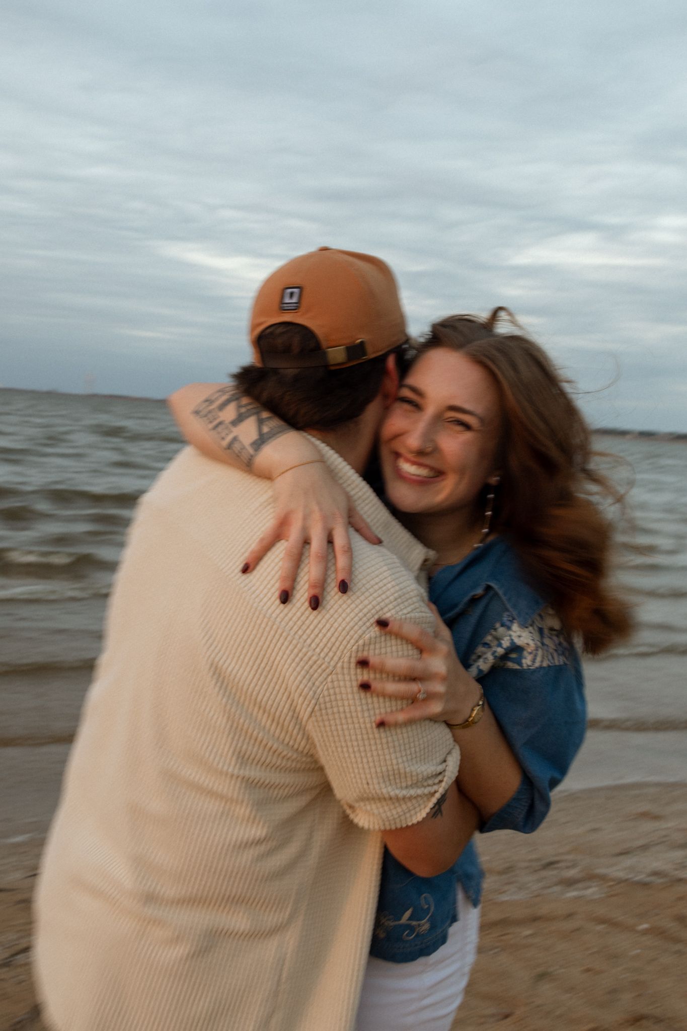 A joyful embrace shared on the beach during golden hour.
