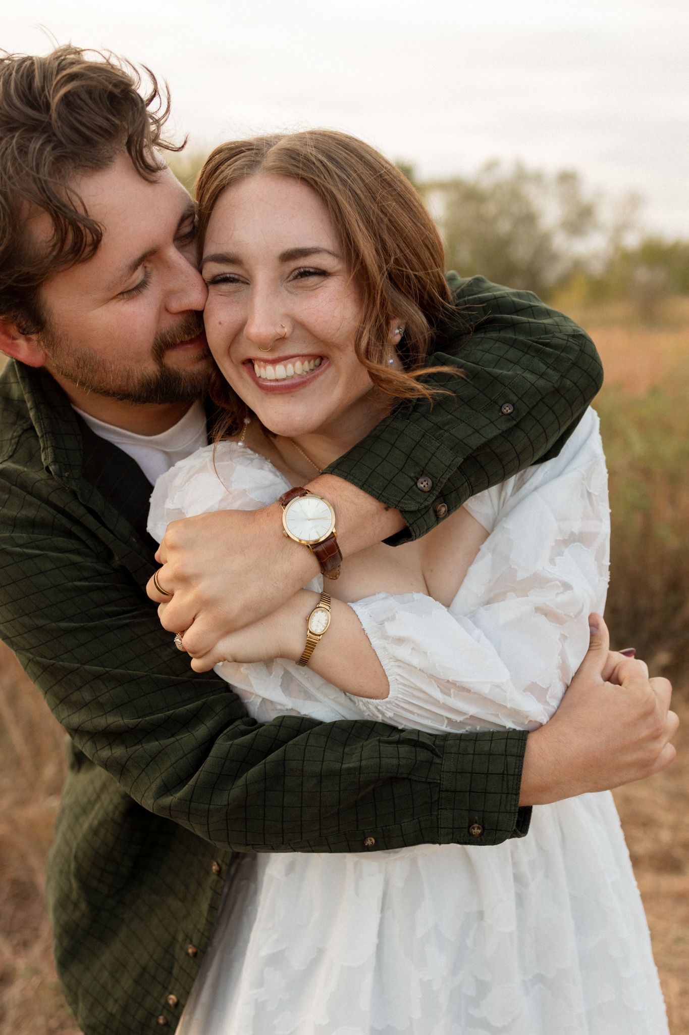 Intimate embrace captured during sunset engagement session in autumn field.