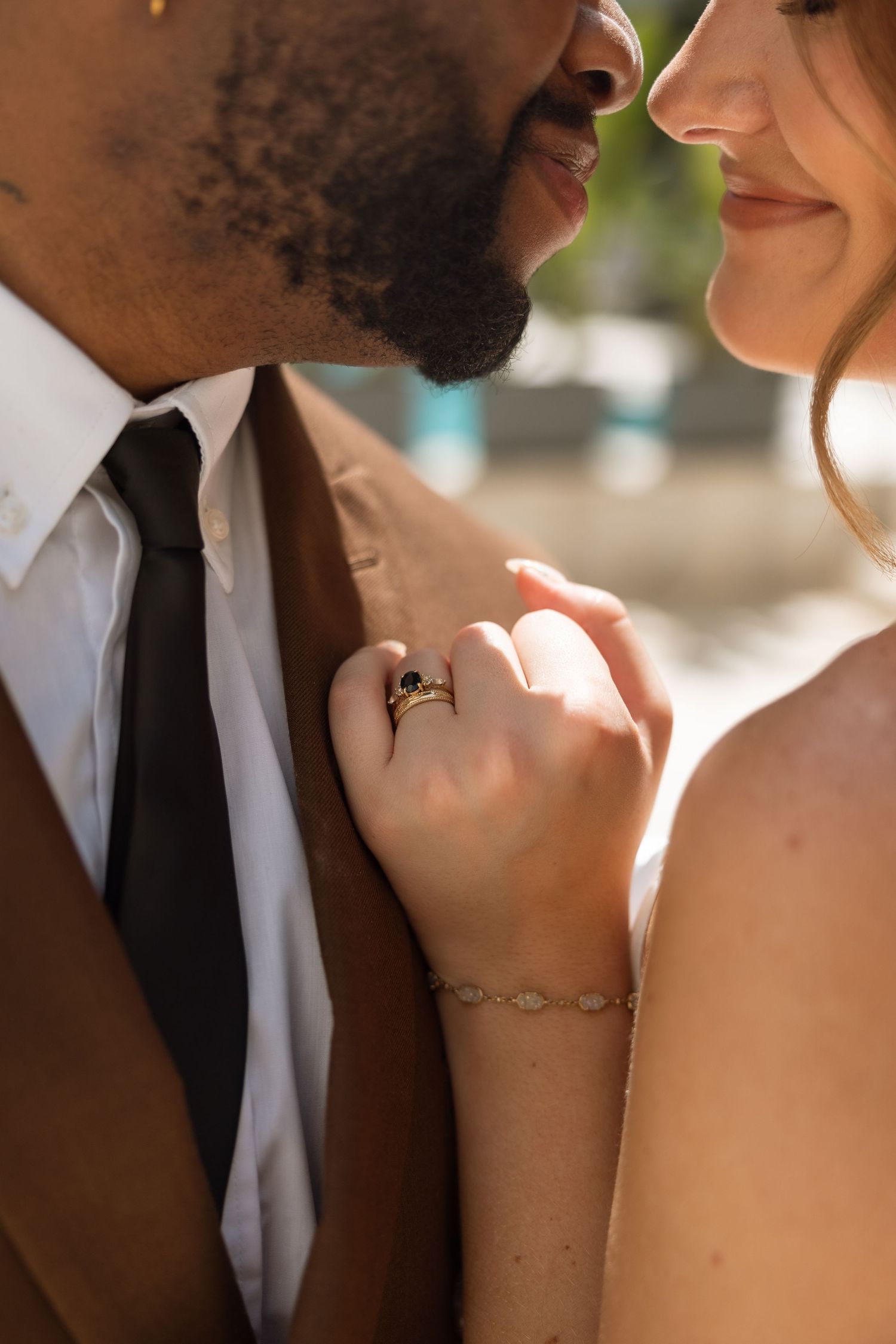Close-up detail shot of wedding rings and intimate moment between couple.