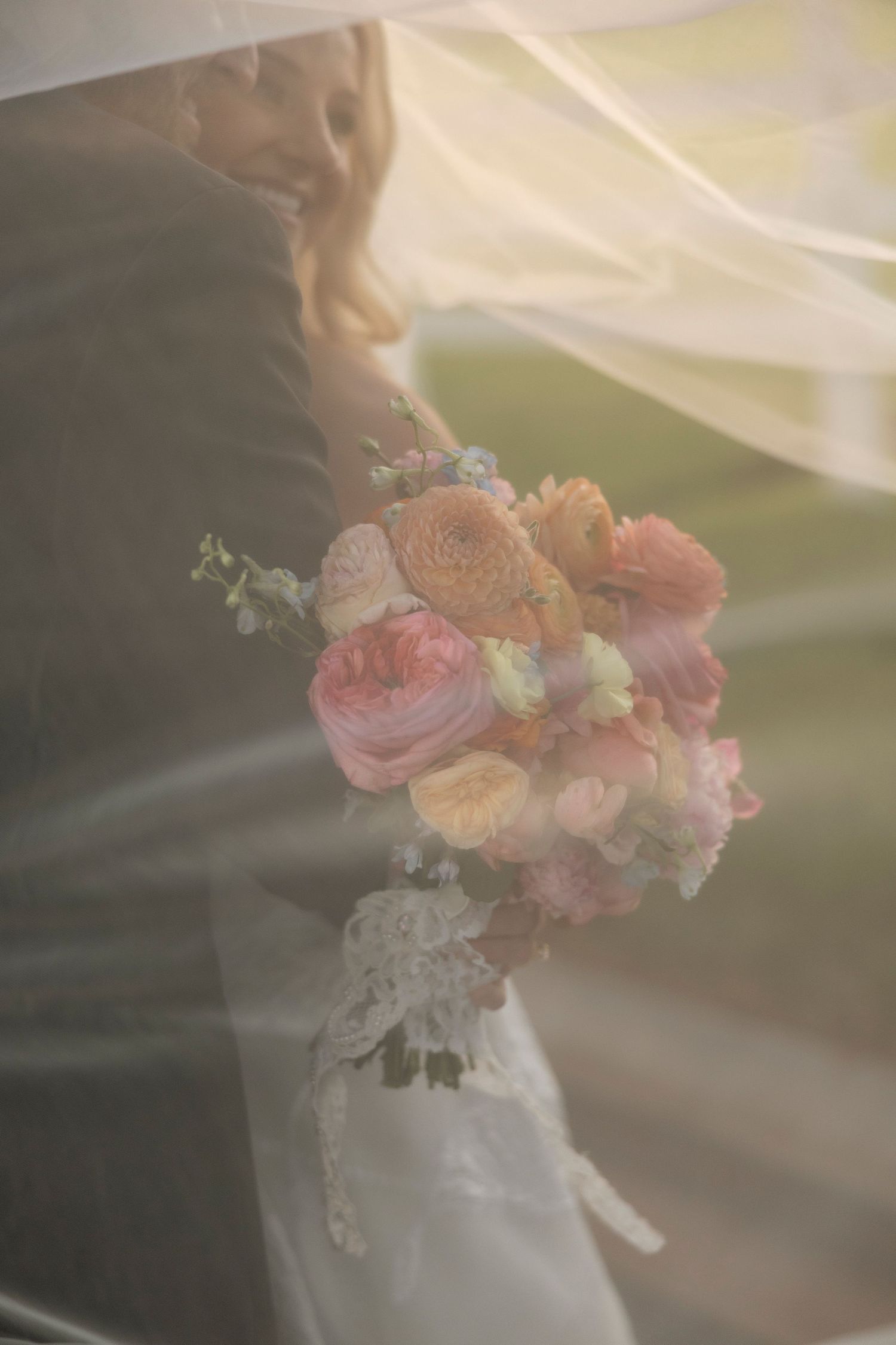 Soft focus close-up of delicate pink and peach floral bouquet details with dreamy lighting.