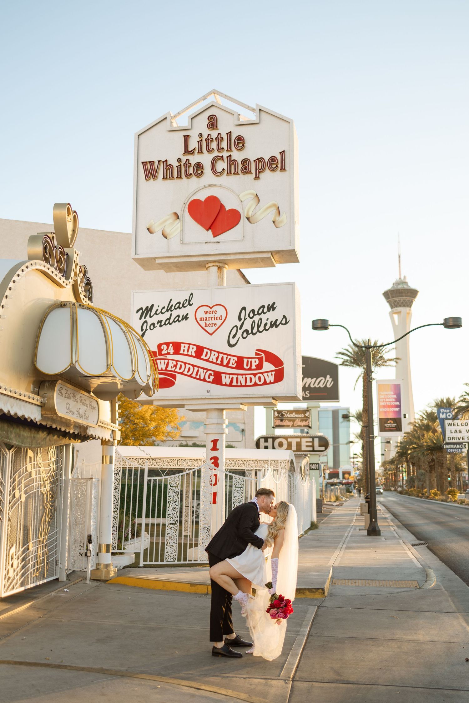 Newlyweds share a kiss under the Little White Chapel sign in Las Vegas.
