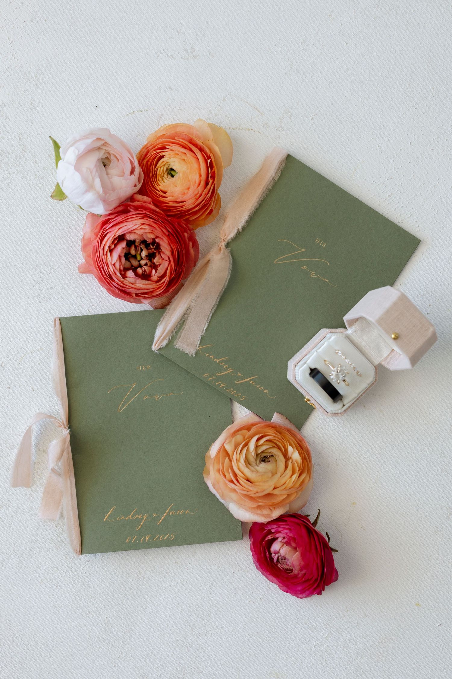 Elegant wedding invitations in sage green with delicate pink and orange ranunculus flowers.
