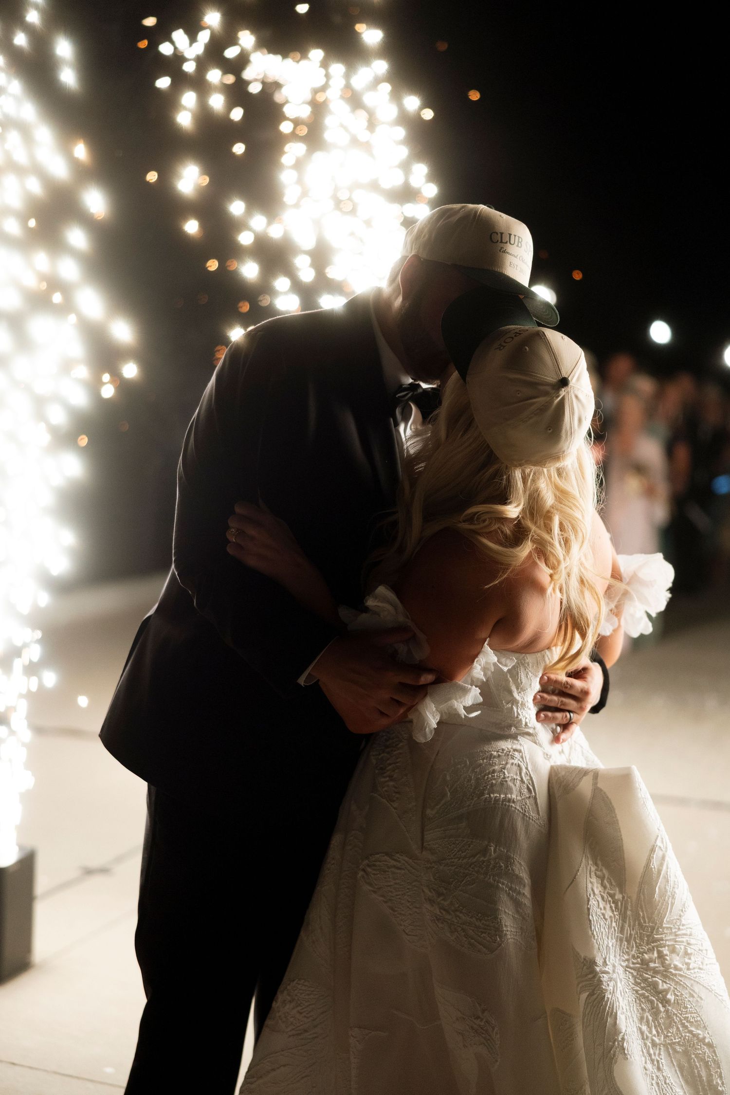 A romantic wedding moment with sparklers creating a magical backdrop as a couple embraces on their special night.