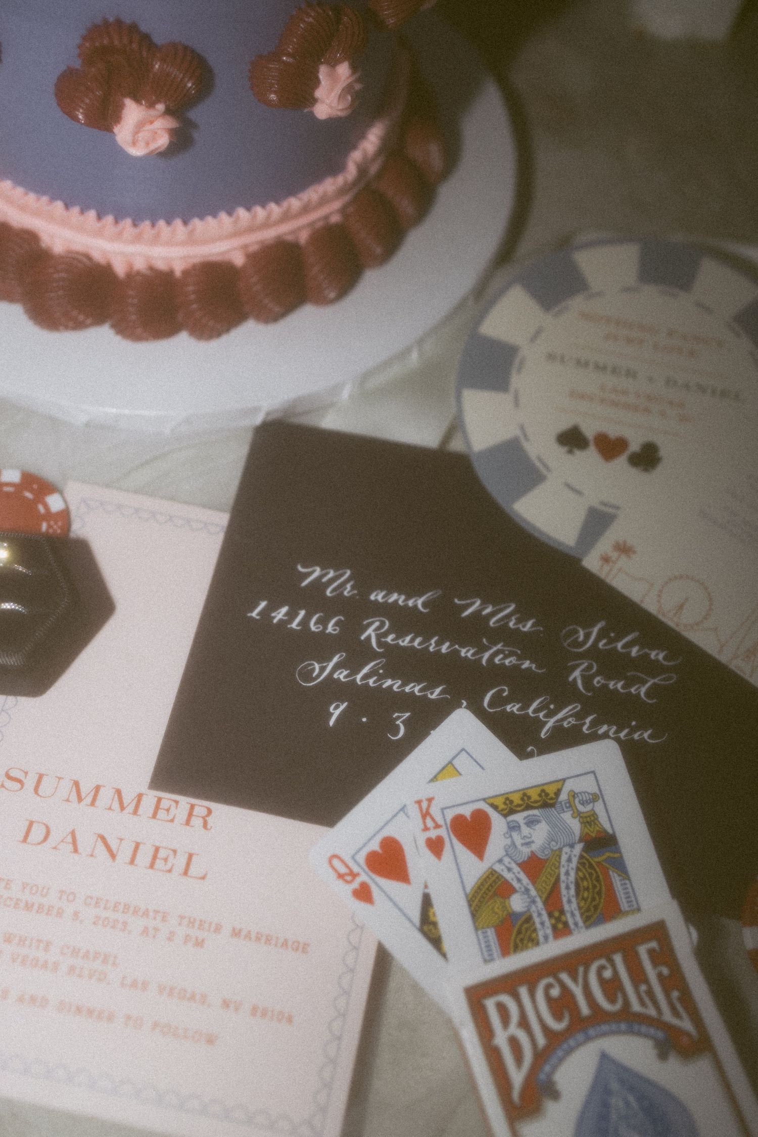Wedding invitation details with playing cards and poker chips in a vintage-style photograph.