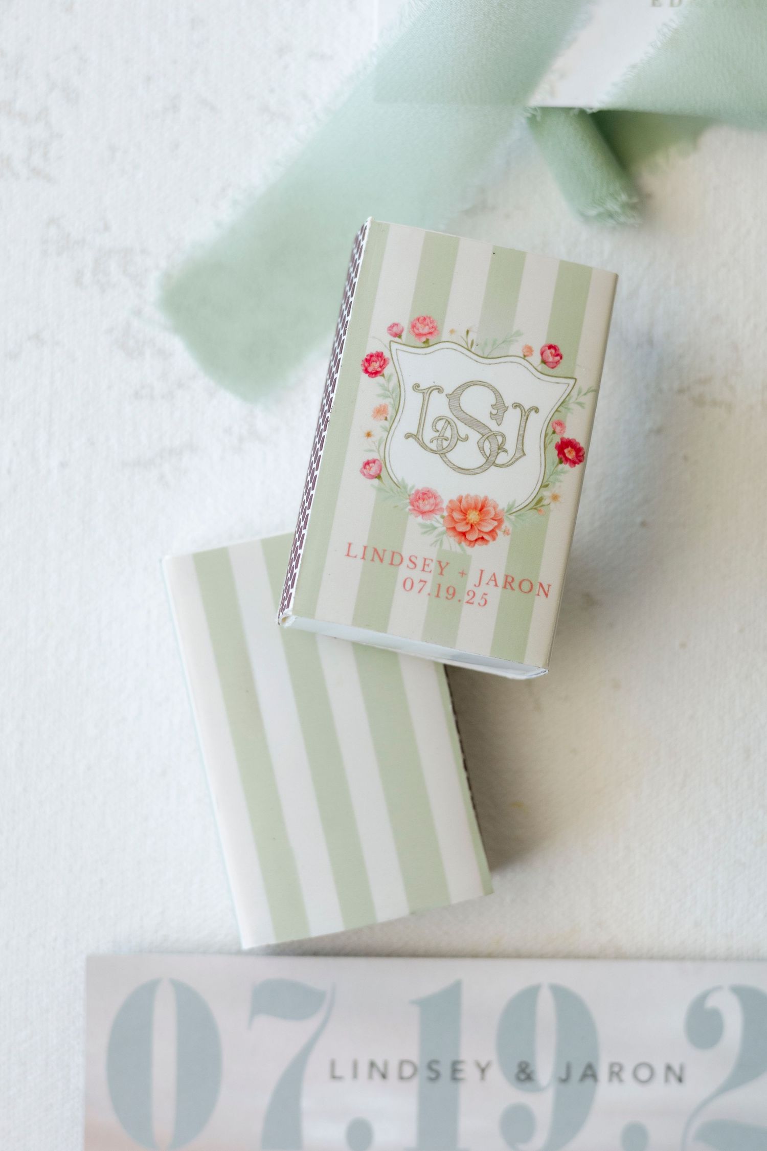 Elegant wedding invitation suite with gray stripes and floral details in soft pastel colors.