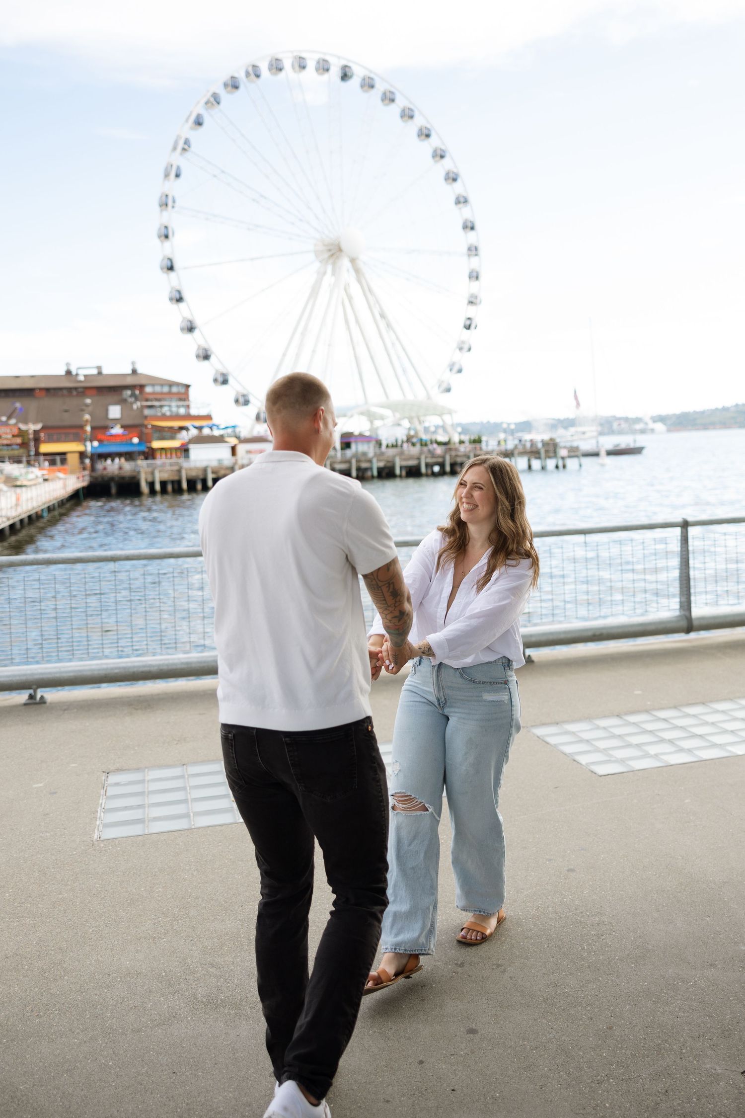 Couple dancing by the Seattle waterfront with the Great Wheel in background.