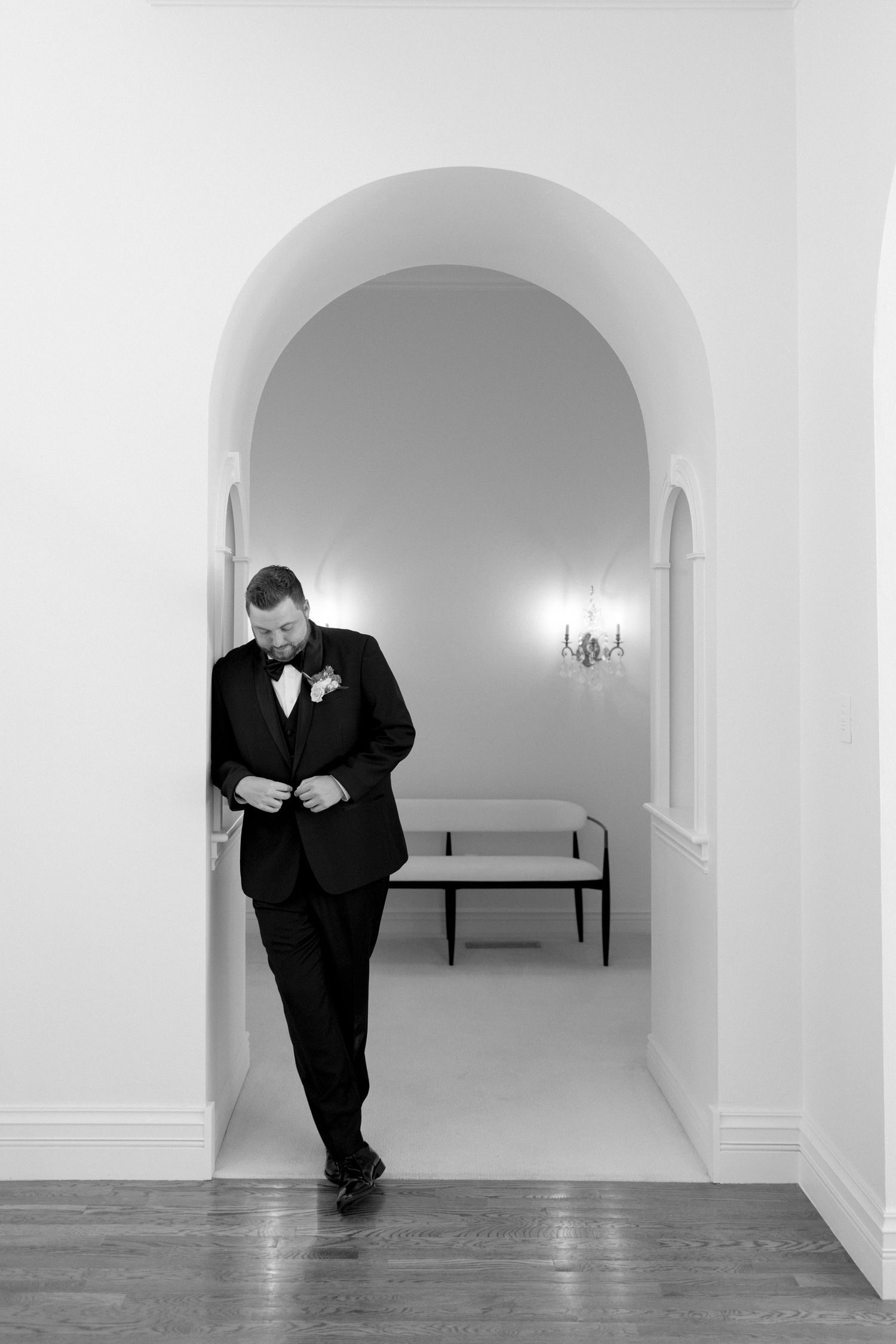 Black and white artistic portrait series in a minimalist hallway with arched doorways.