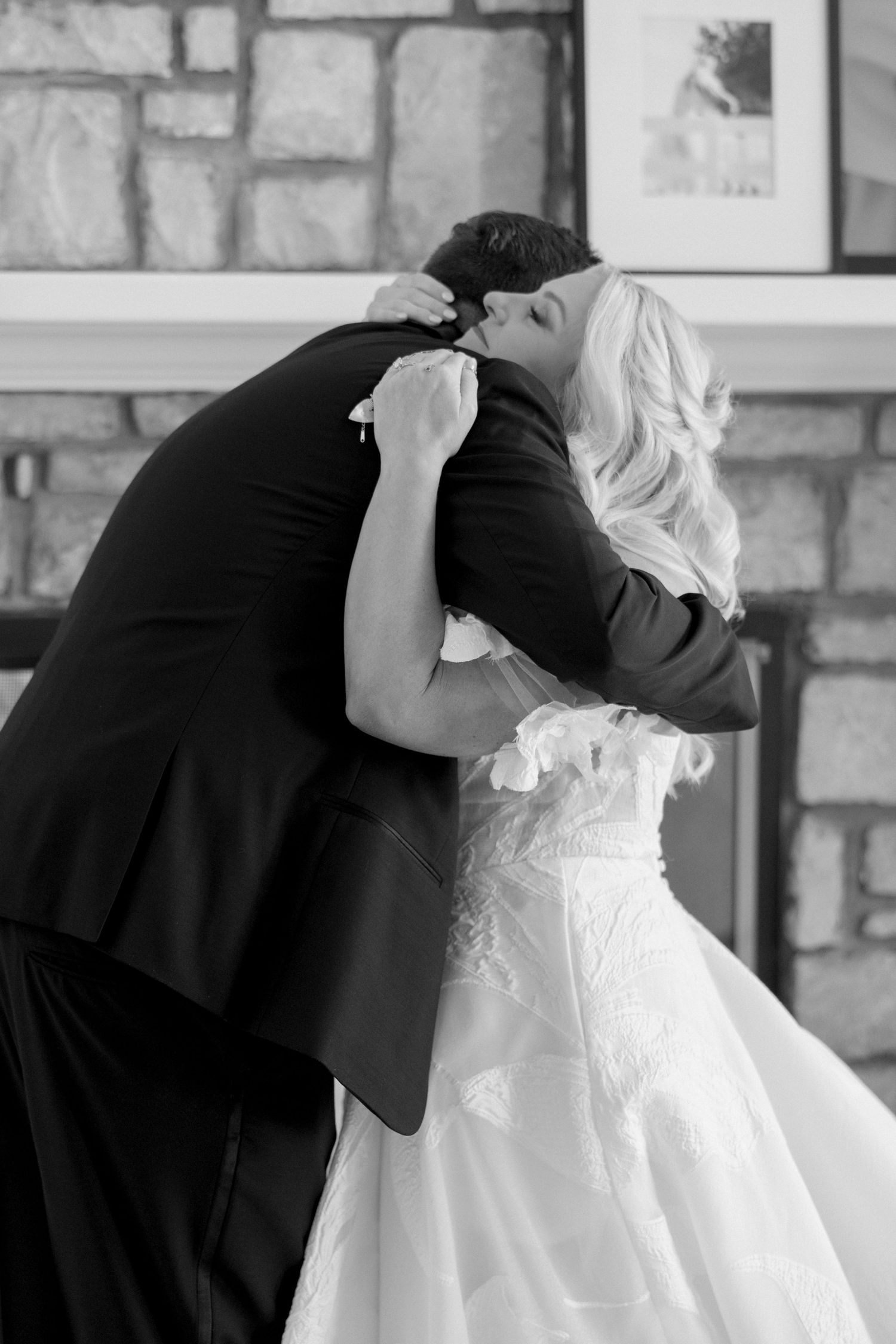 Black and white photo sequence capturing intimate wedding moments against a stone wall backdrop.