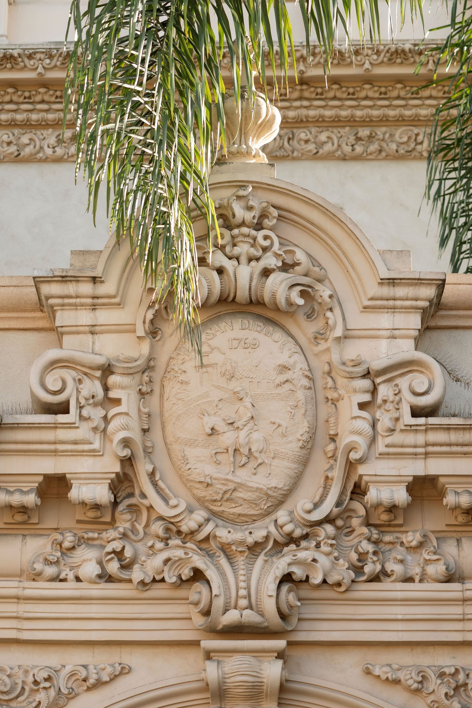 Ornate stone architectural details with decorative carvings and palm fronds visible at the top.