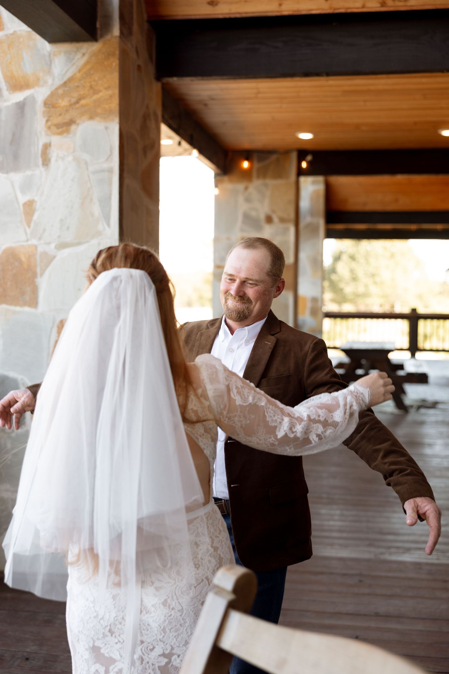 Sweet moment during a first look on a stone and wood porch.
