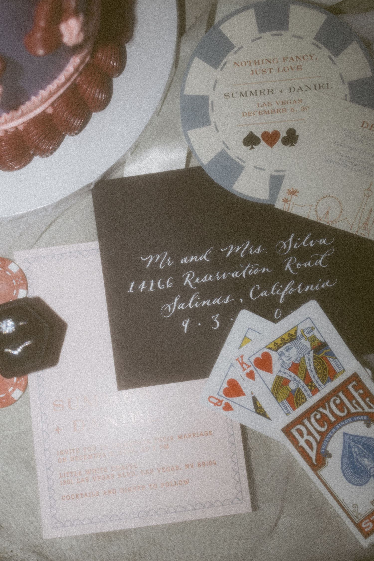 Wedding stationery featuring cards, poker chips, and calligraphy addressing in Las Vegas theme.