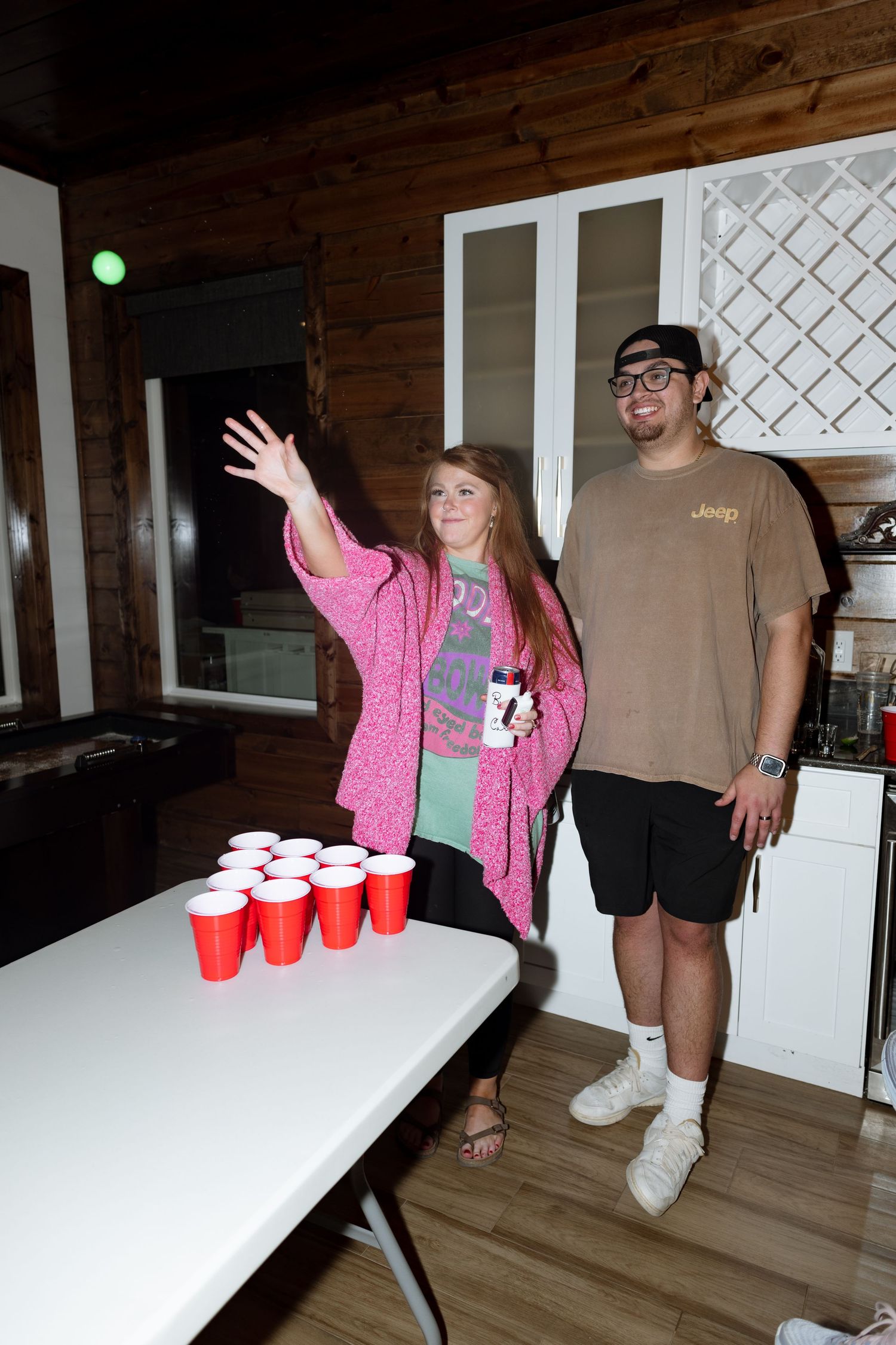 Players enjoying a game of beer pong at an indoor party setting.