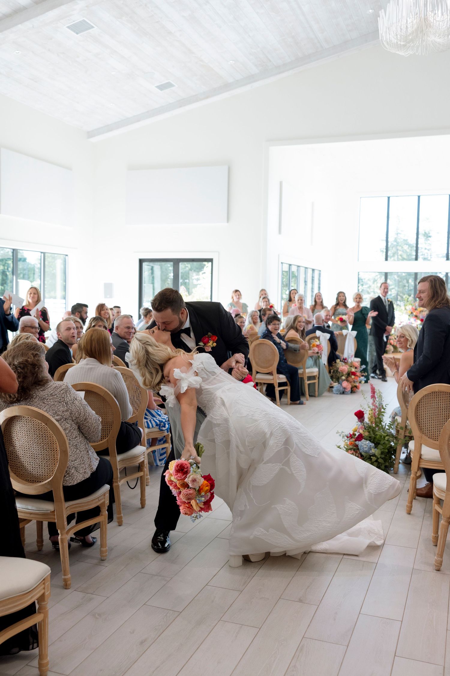 Wedding ceremony with guests seated in elegant chairs watching the celebration.