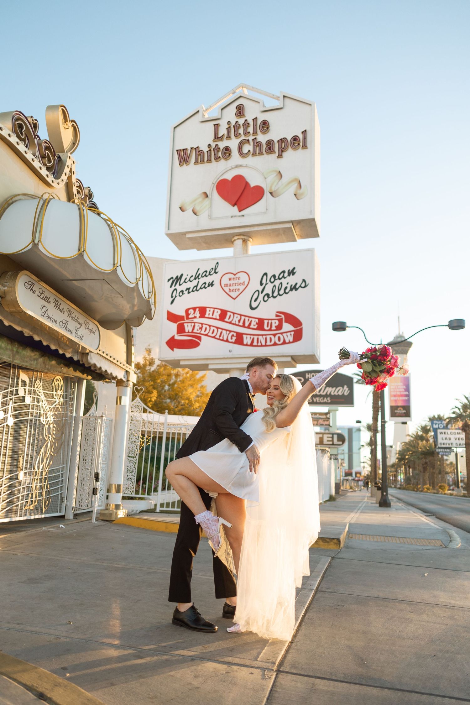 Newlyweds pose for fun photos outside the Little White Chapel on the Las Vegas strip.