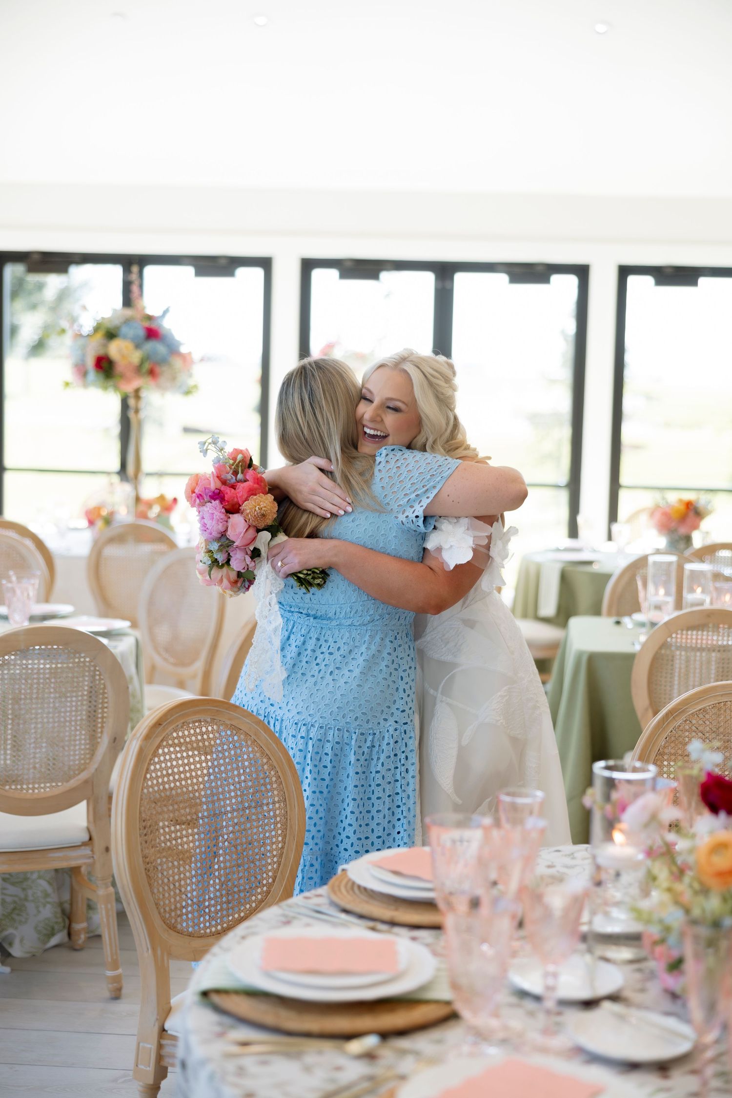 Reception table setting with cane back chairs and colorful floral centerpieces.