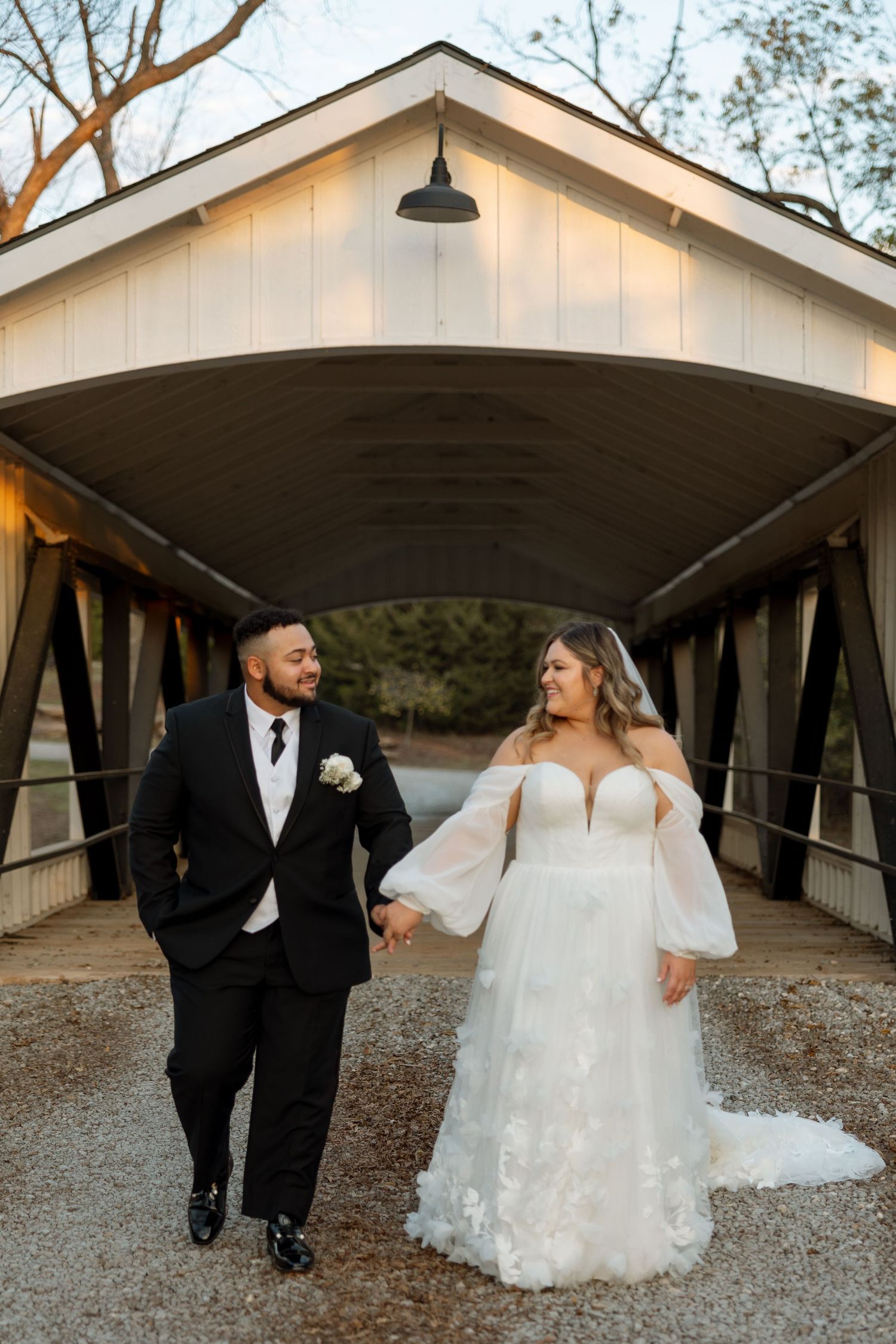 A sunset wedding portrait on a covered bridge with dramatic lighting.