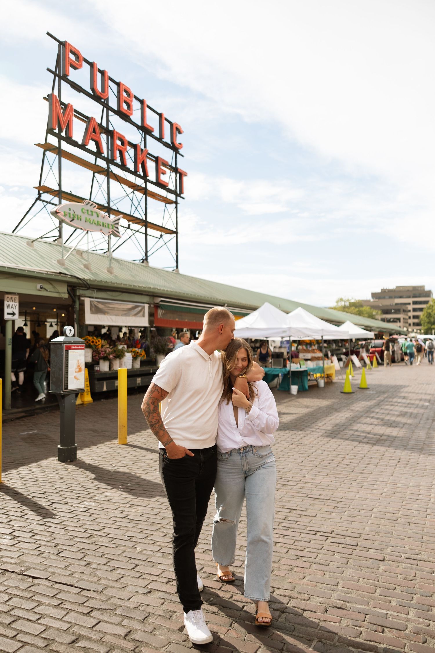 A couple enjoys a tender moment while walking through Pike Place Market in Seattle.