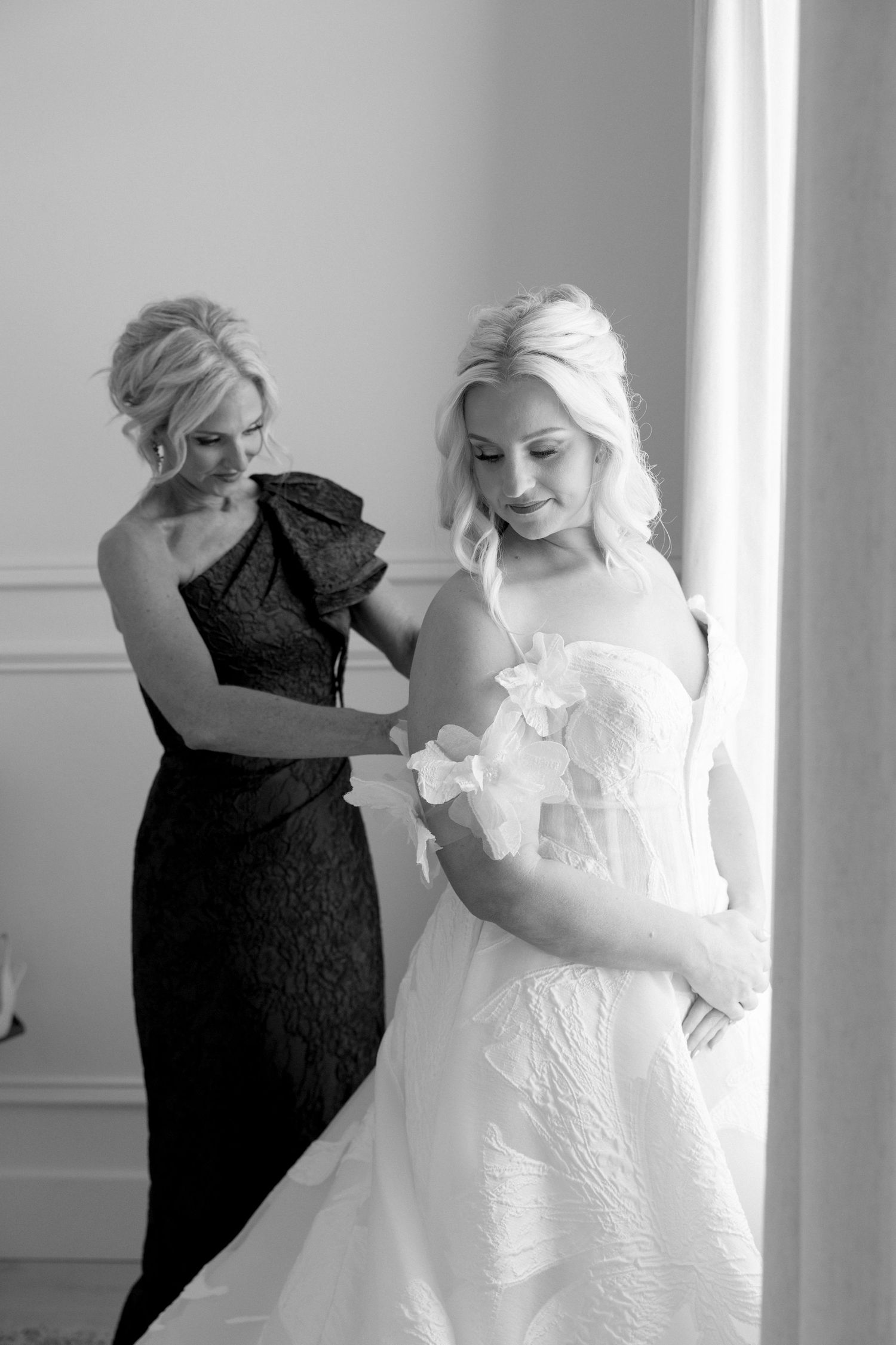 Getting ready scene with wedding dress being prepared in bright white room.
