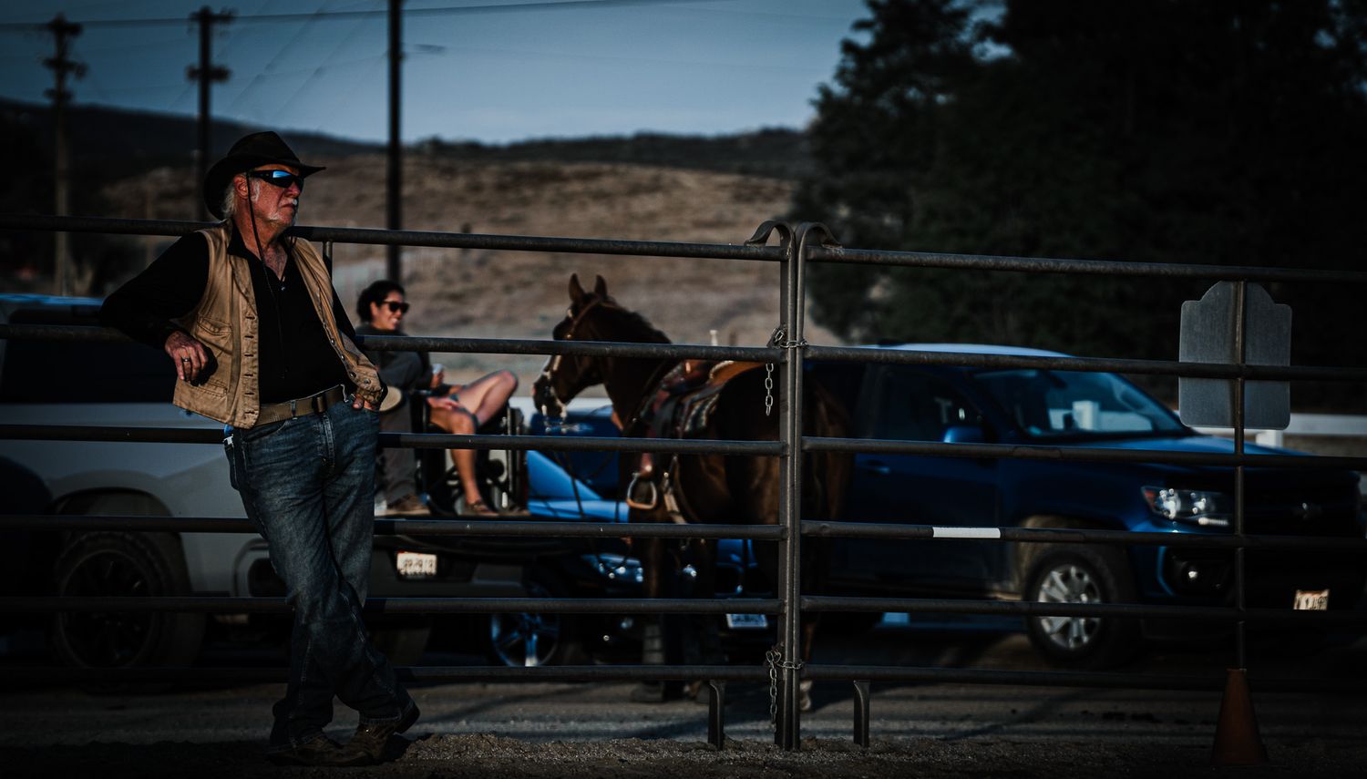 Cowboy standing along an arena fence at a Southern California Western event