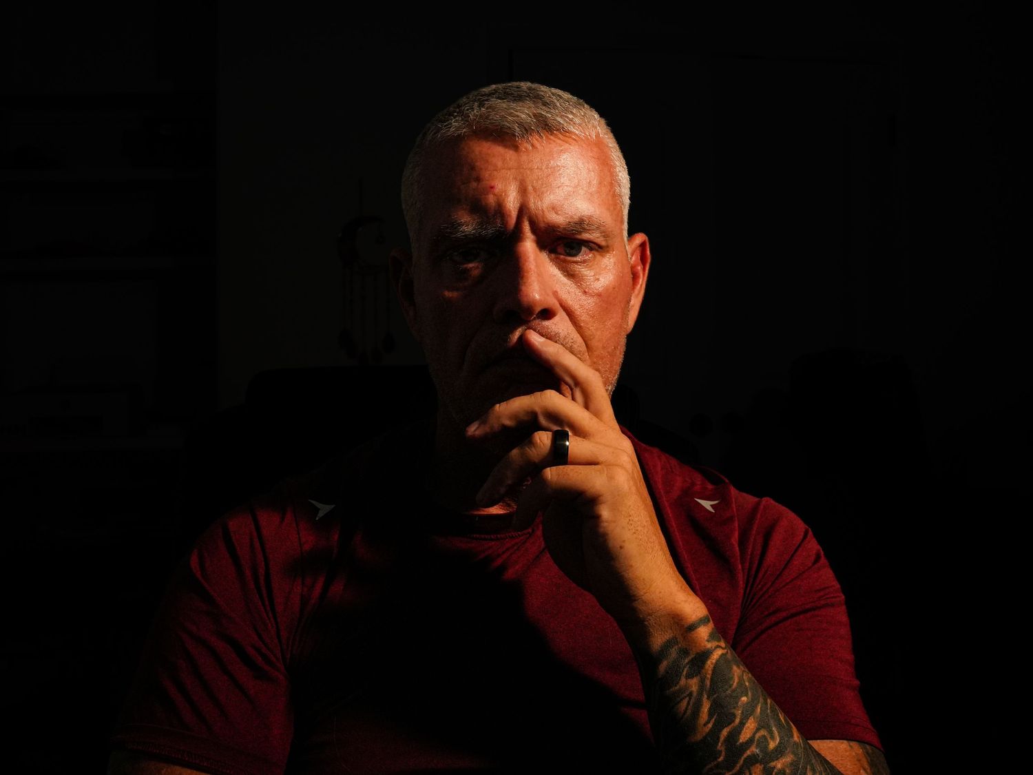 Moody self-portrait of Amarillo photographer Jon Chaffin seated in shadow with one hand against his face