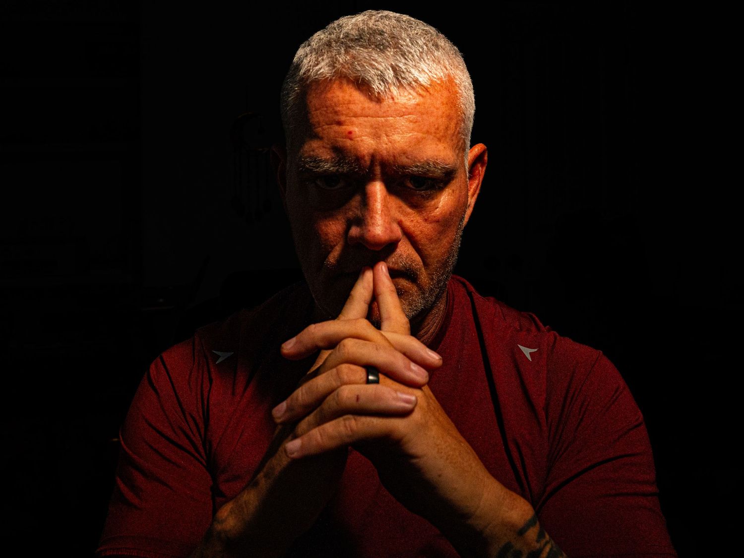 Dramatic low-key self-portrait of Amarillo photographer Jon Chaffin with hands resting thoughtfully against his face