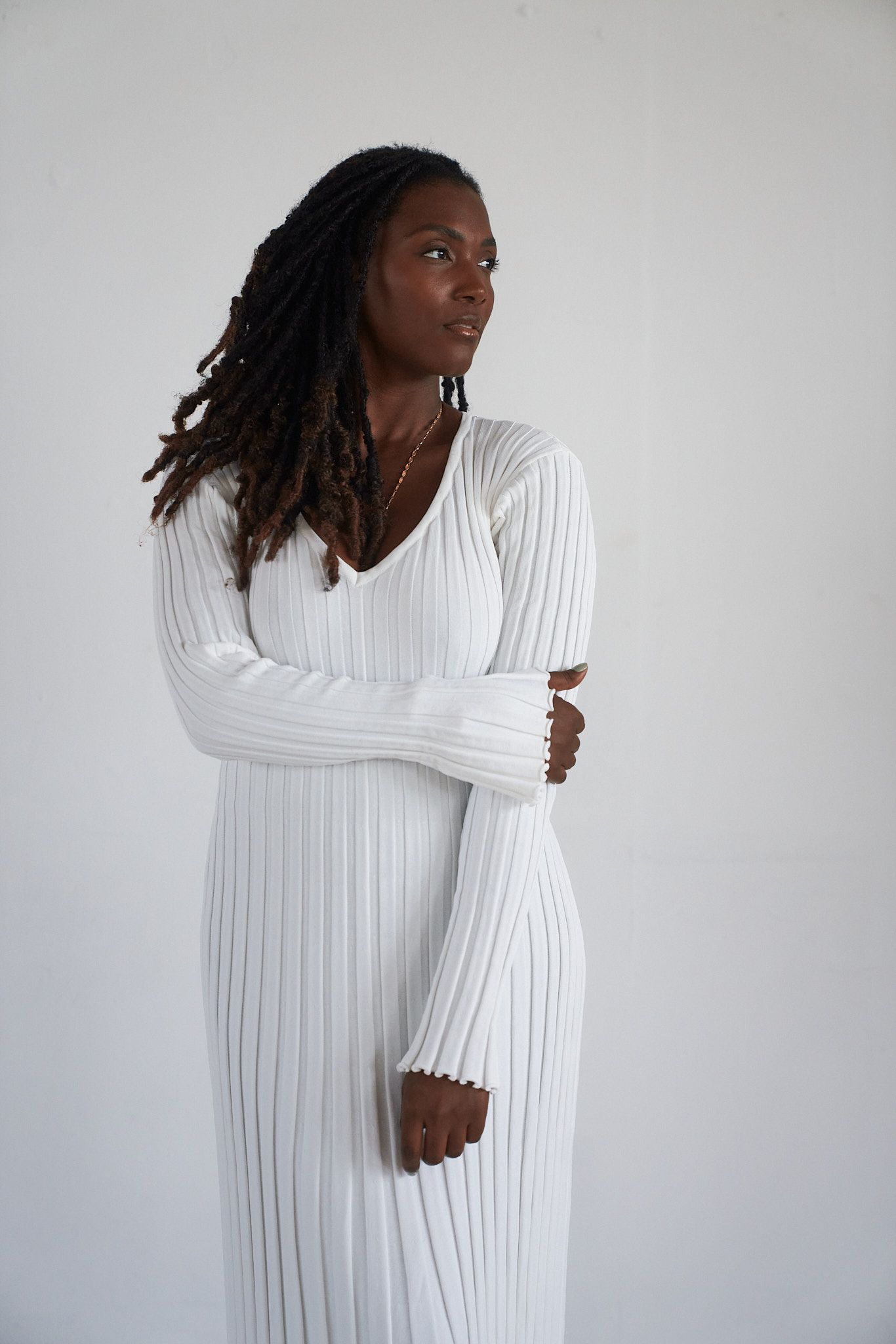Portrait de Marcie Monfret, photographe au Havre, en robe blanche sur fond clair