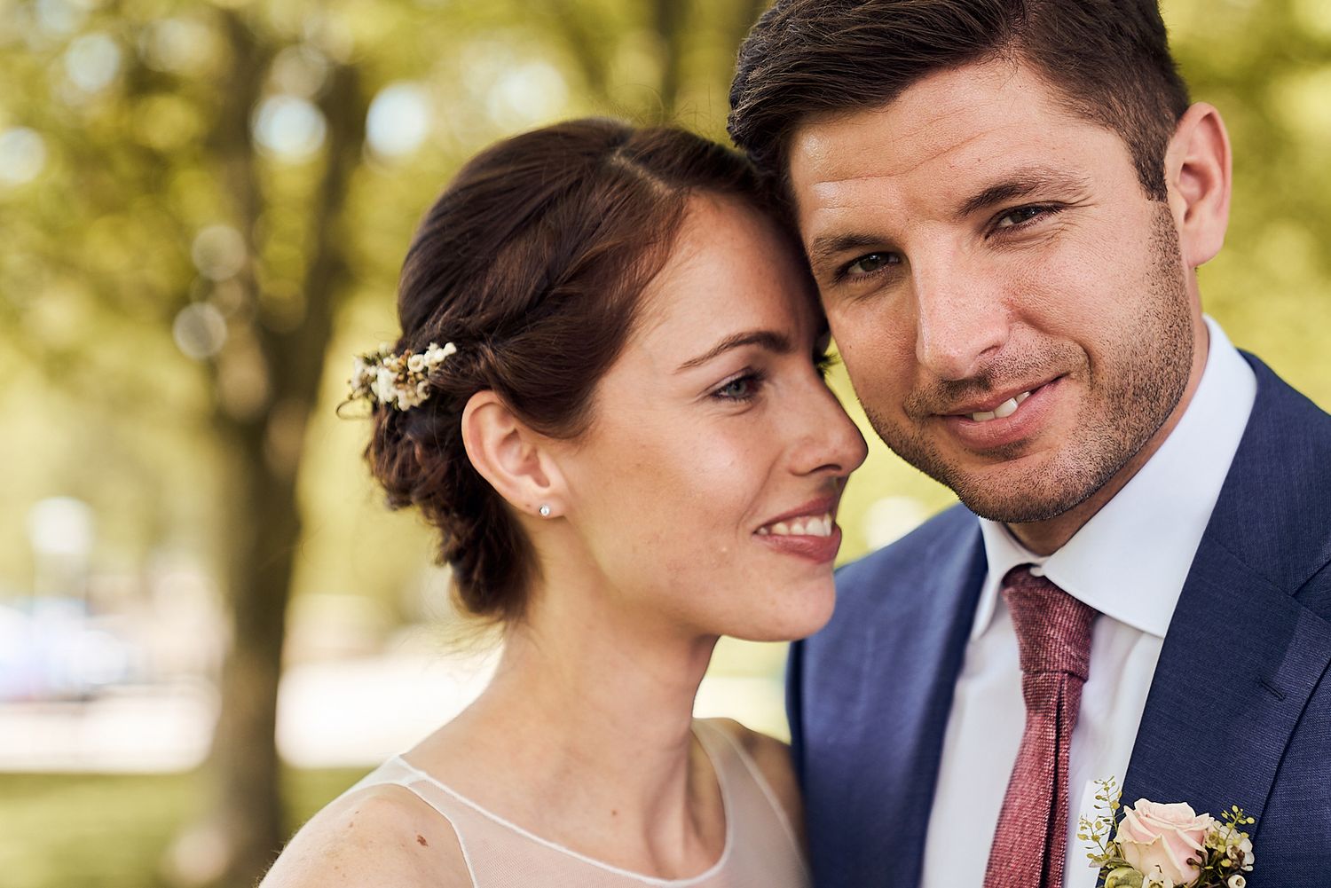 Mariés souriants dans un paysage enneigé, bouquet de fleurs à la main, mariage d'hiver