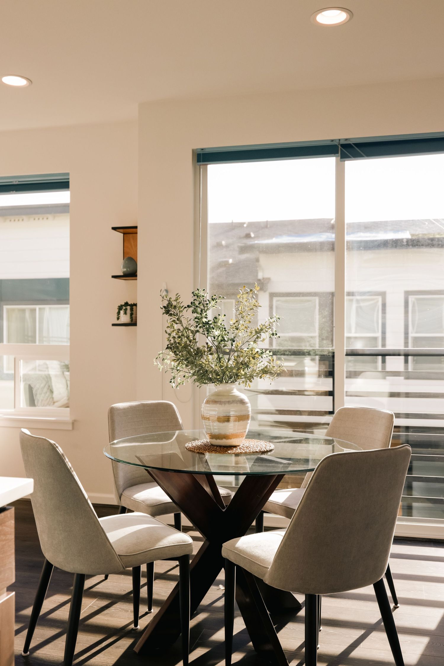 Staged interior dining room with large windows overlooking the surrounding neighborhood.