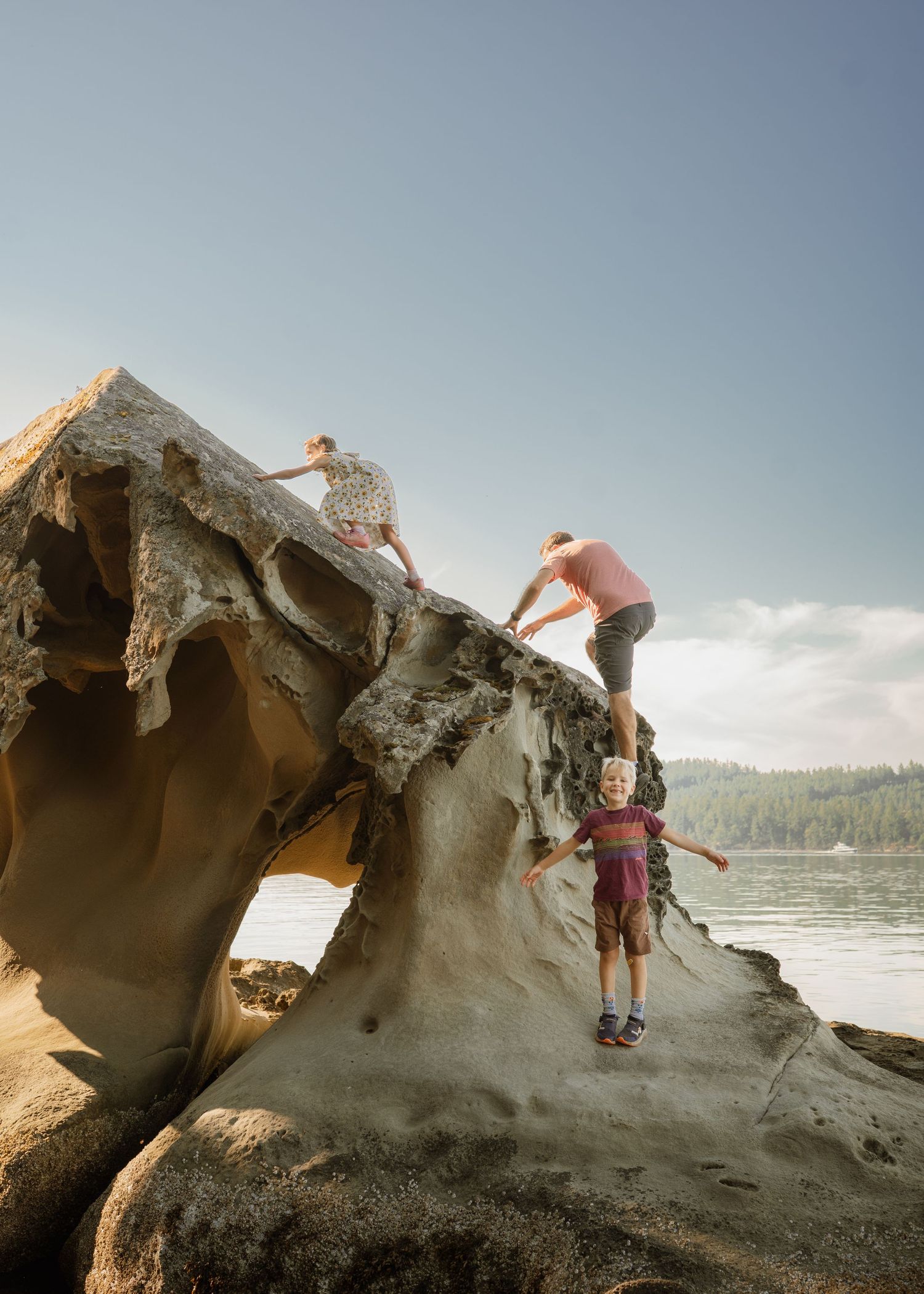 Rock climbers explore unique sandstone formations along a scenic beach coastline during a sunny day.
