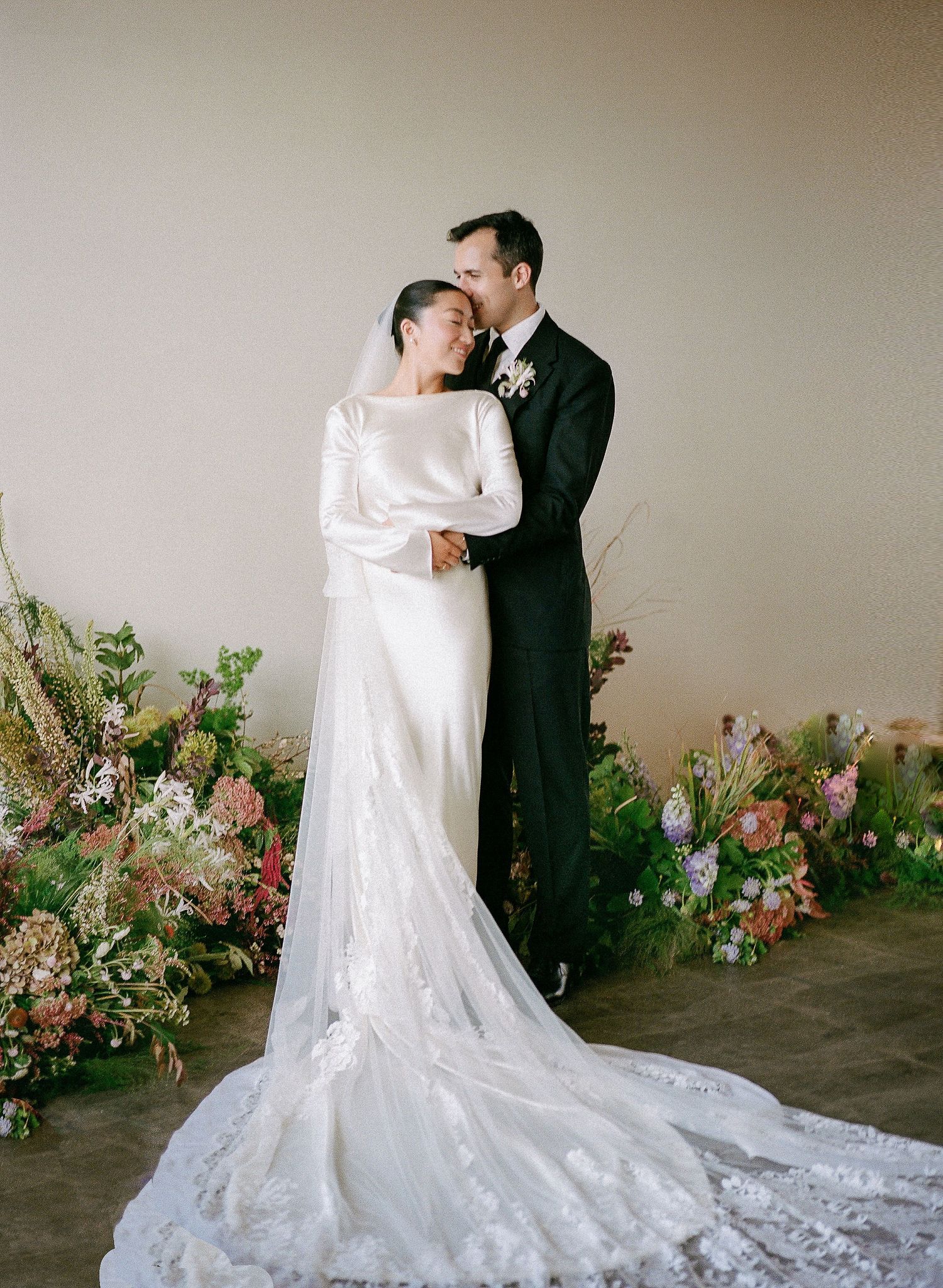 A romantic wedding photoshoot sequence showing a couple in formal attire against a floral backdrop.