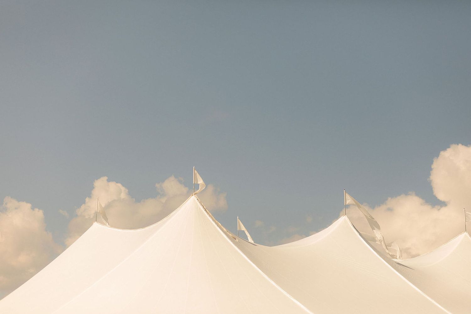 A panoramic view of puffy white clouds against a light blue sky during daytime.