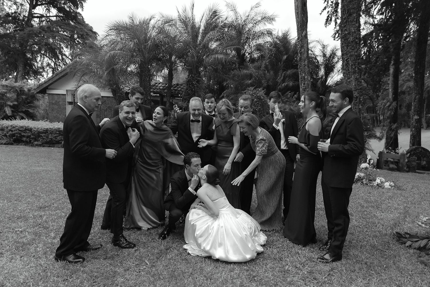 Wedding party members gather outdoors for a creative photo sequence showing playful poses in black and white.