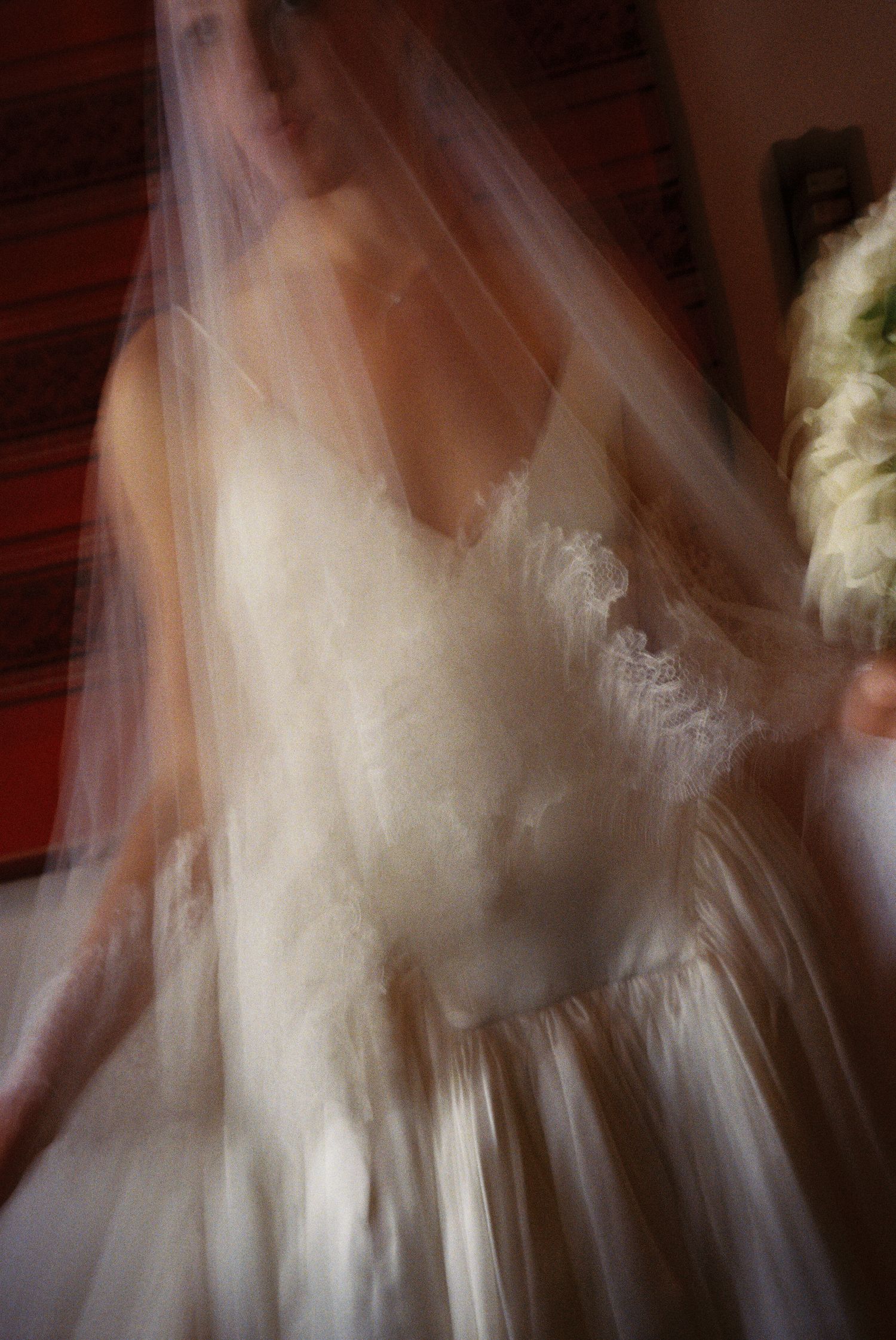 Ethereal wedding dress with flowing veil captured in soft motion blur creating a dreamy romantic atmosphere.