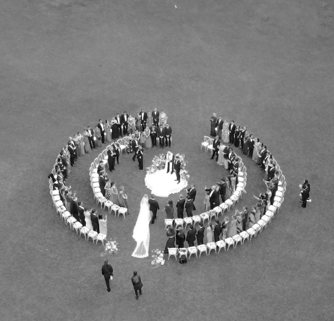 Aerial black and white photo of people arranged in a peace symbol formation on the ground.