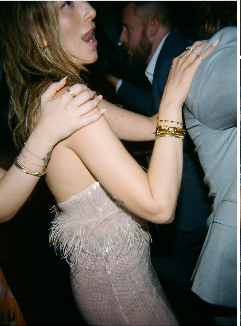 Couple dancing intimately at a dimly lit party wearing formal attire.
