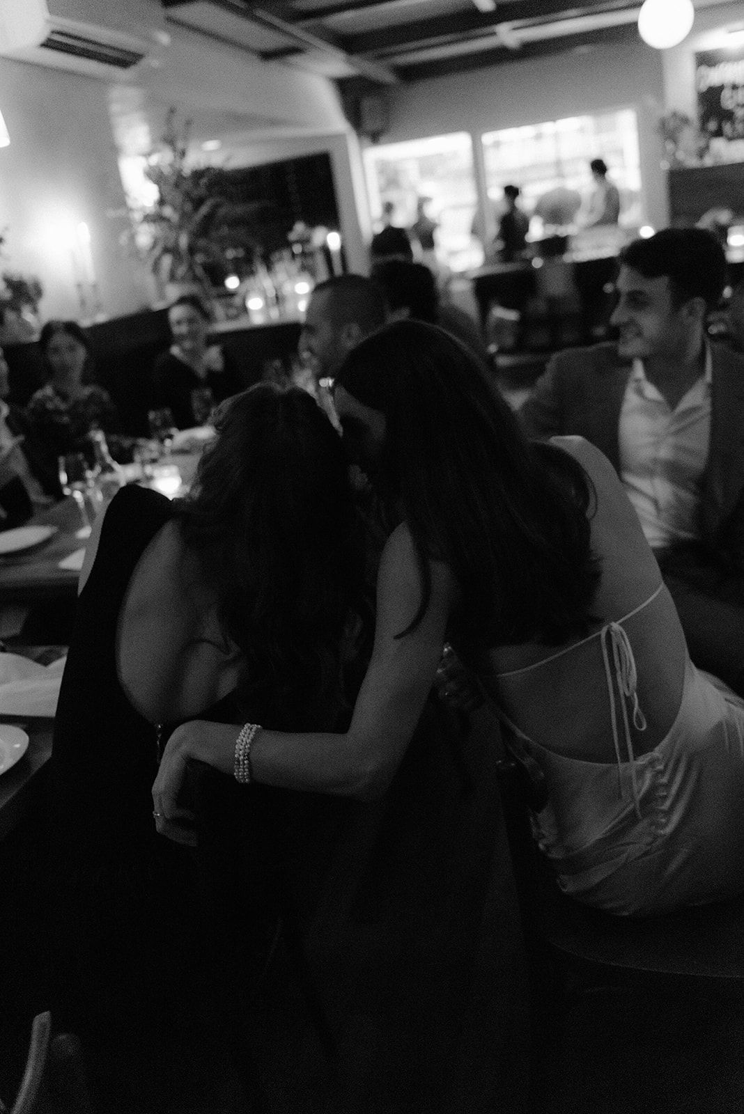 People dancing together in a dimly lit room at what appears to be a social gathering or party.