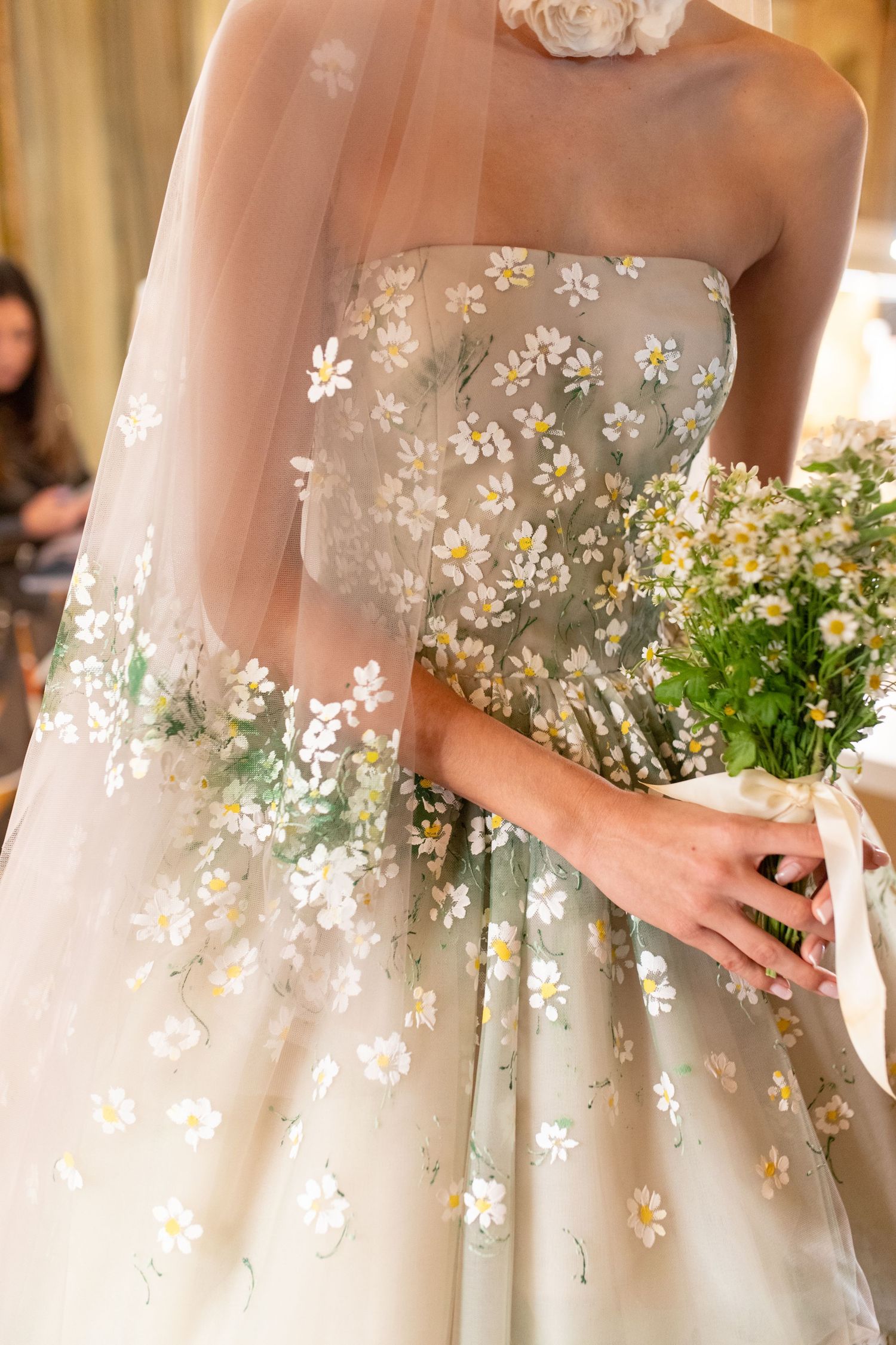 Close-up detail of delicate baby's breath flowers adorning a white wedding dress with soft tulle fabric.