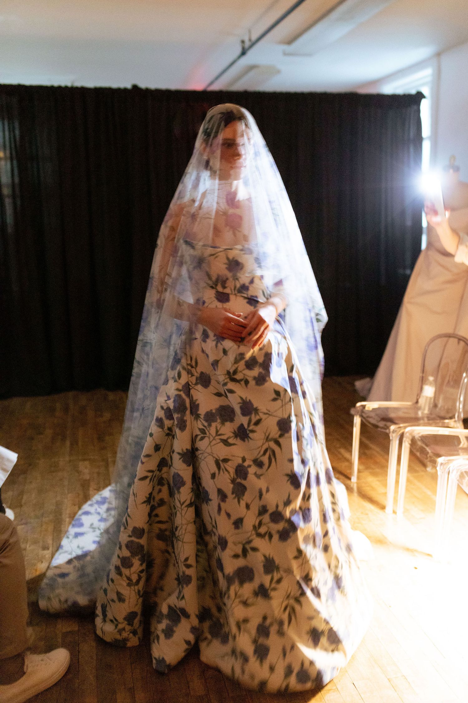 A flowing wedding dress with floral patterns and veil captured in a series of artistic photos.