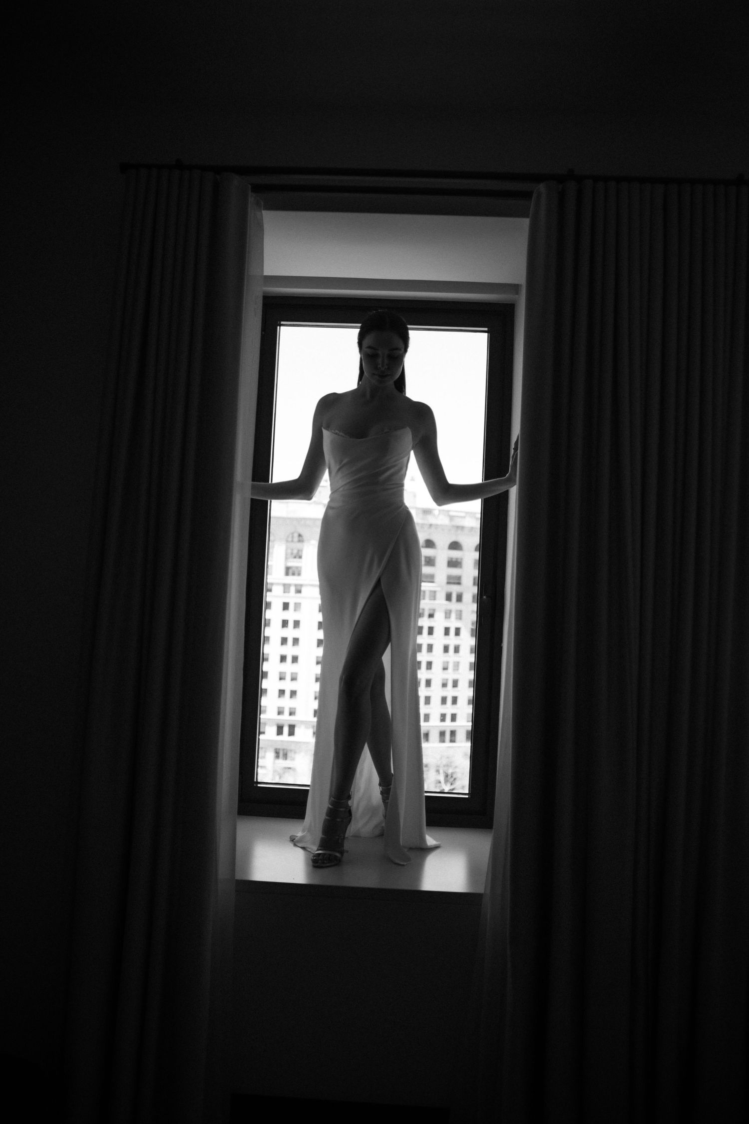 Dramatic black and white silhouette sequence showing a person standing in front of a bright window.