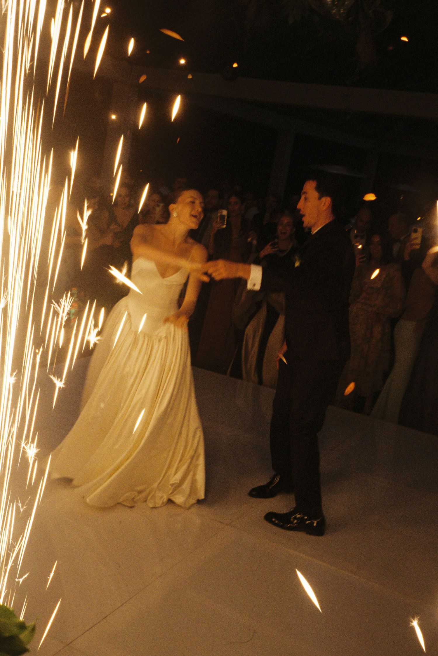 A couple shares their first dance at a wedding reception with dramatic sparkler fountains creating a magical backdrop.