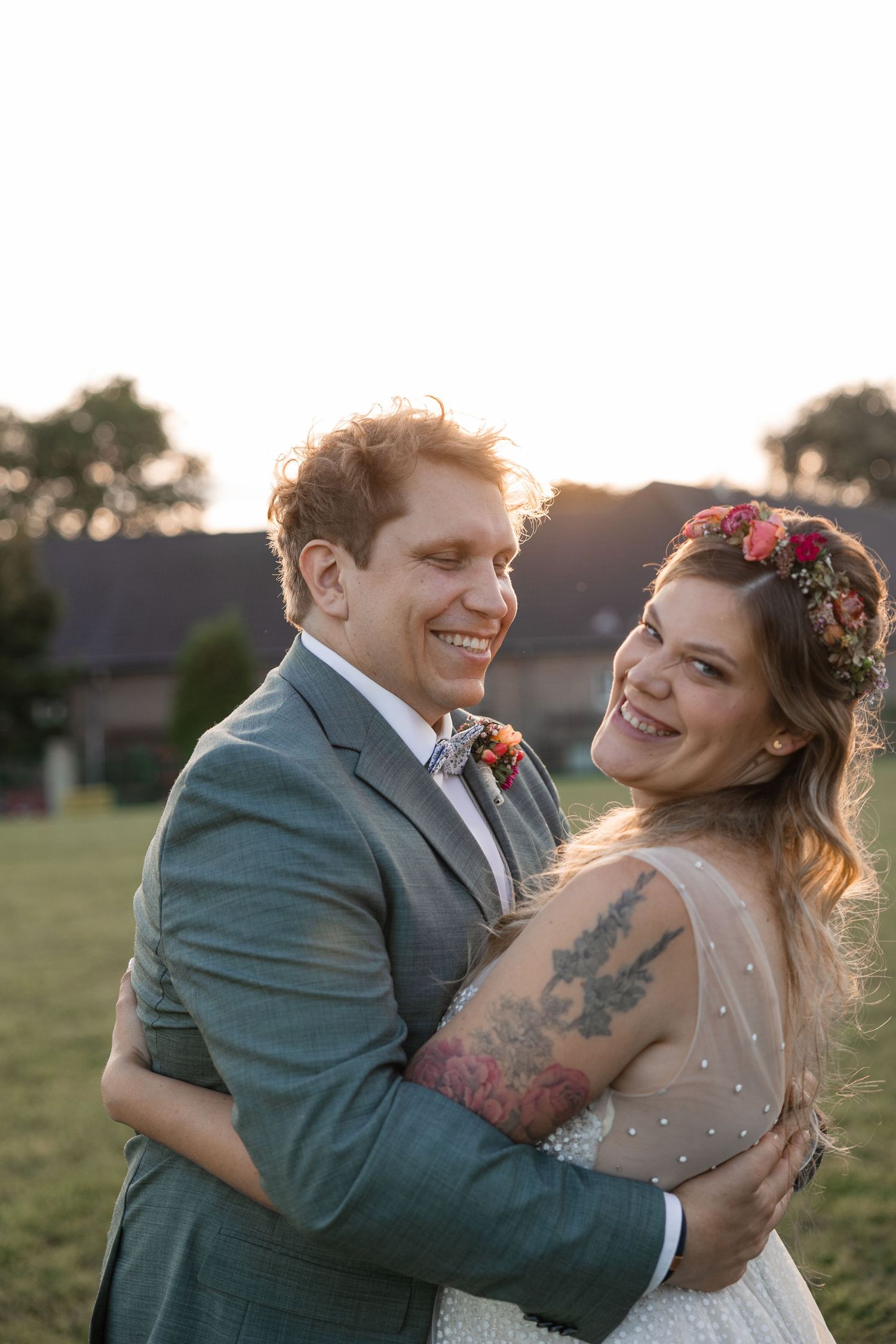 Hochzeitspaar in Grevenbroich beim Fotoshooting im Sonnenuntergang lachend in die Kamera blickend, Foto von Reinhard A. Deutsch